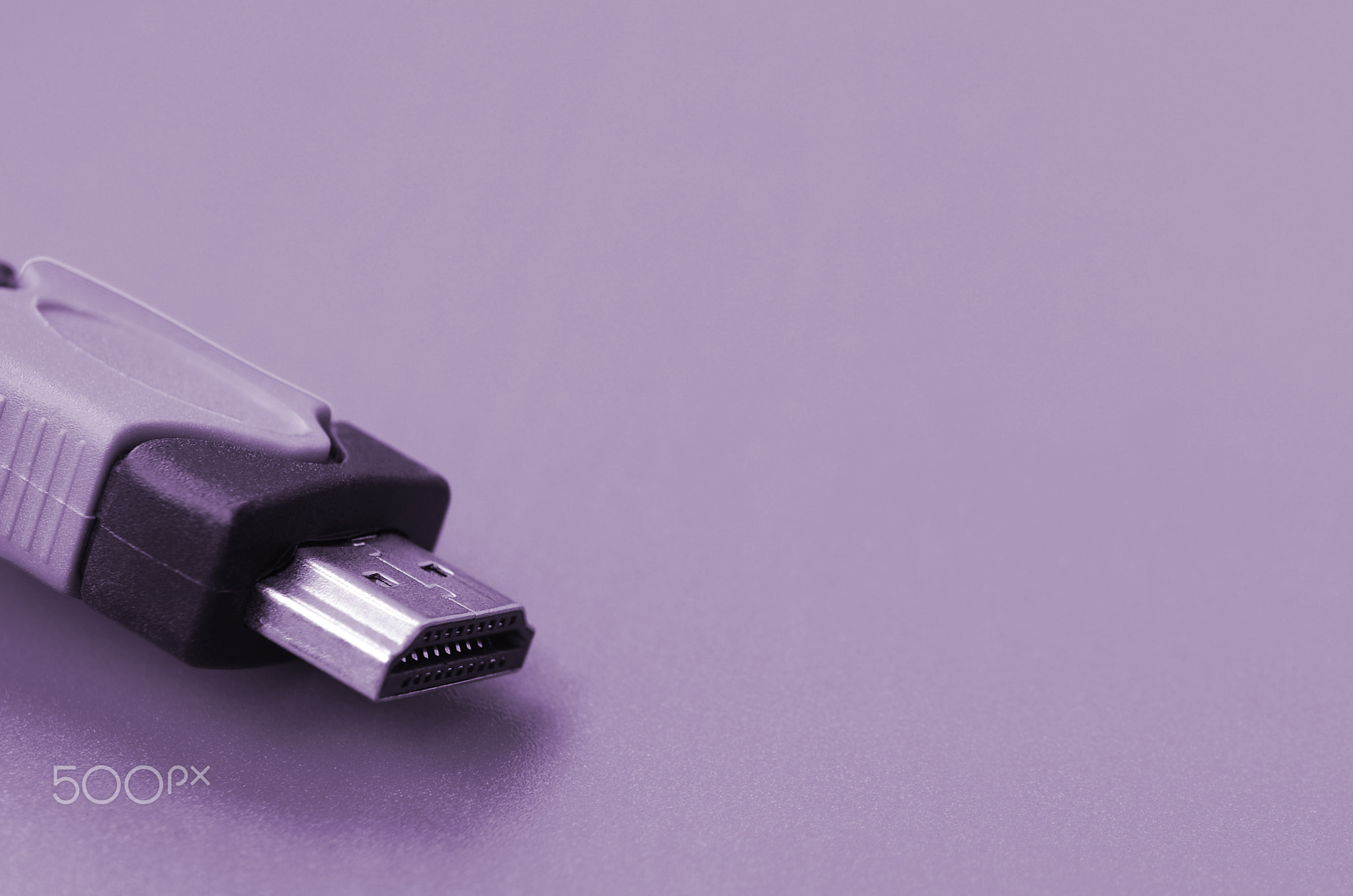 Black audio video HDMI computer cable on purple background. Close up of home entertainment