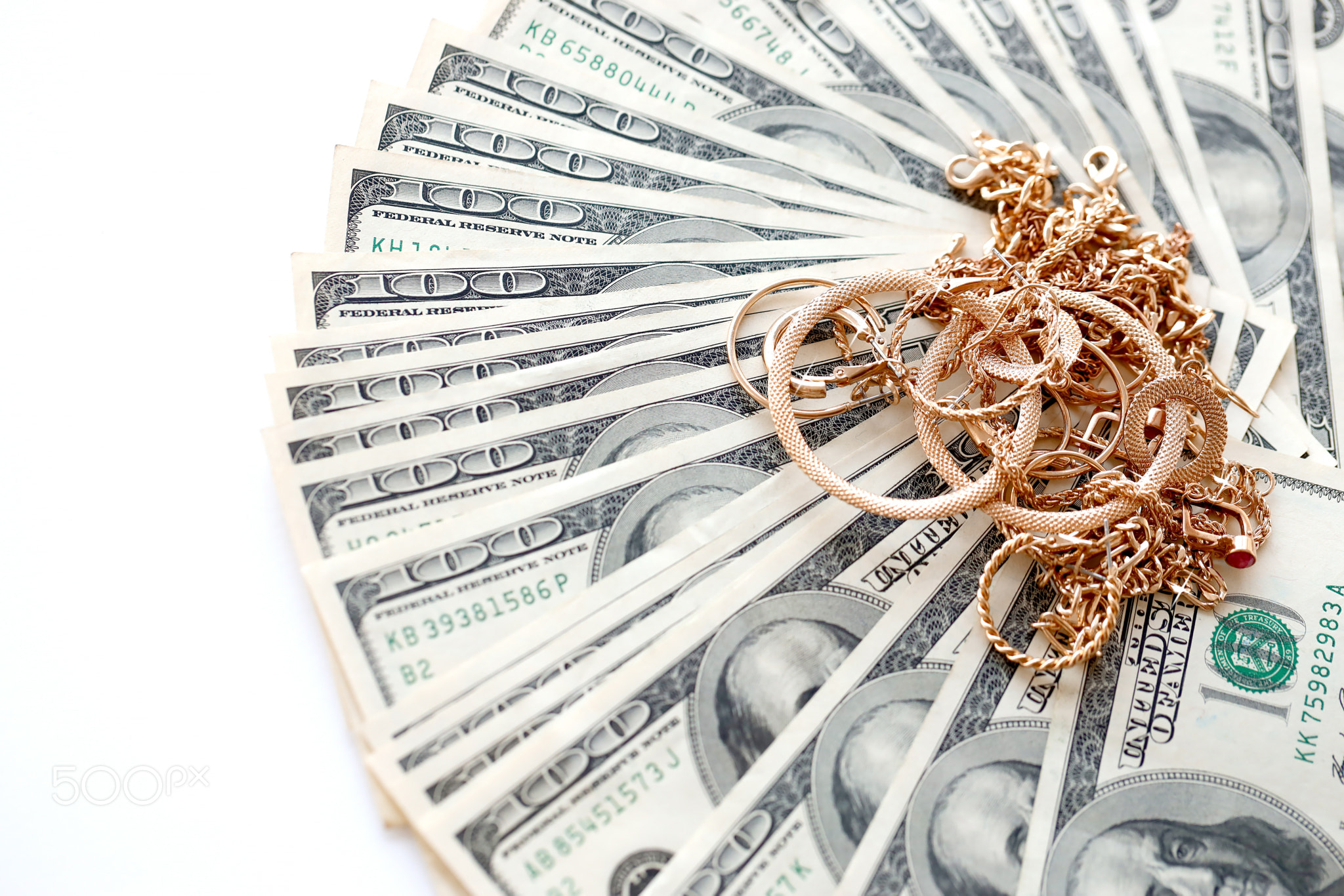 Many expensive golden jewerly rings, earrings and necklaces with big amount of US dollar bills on