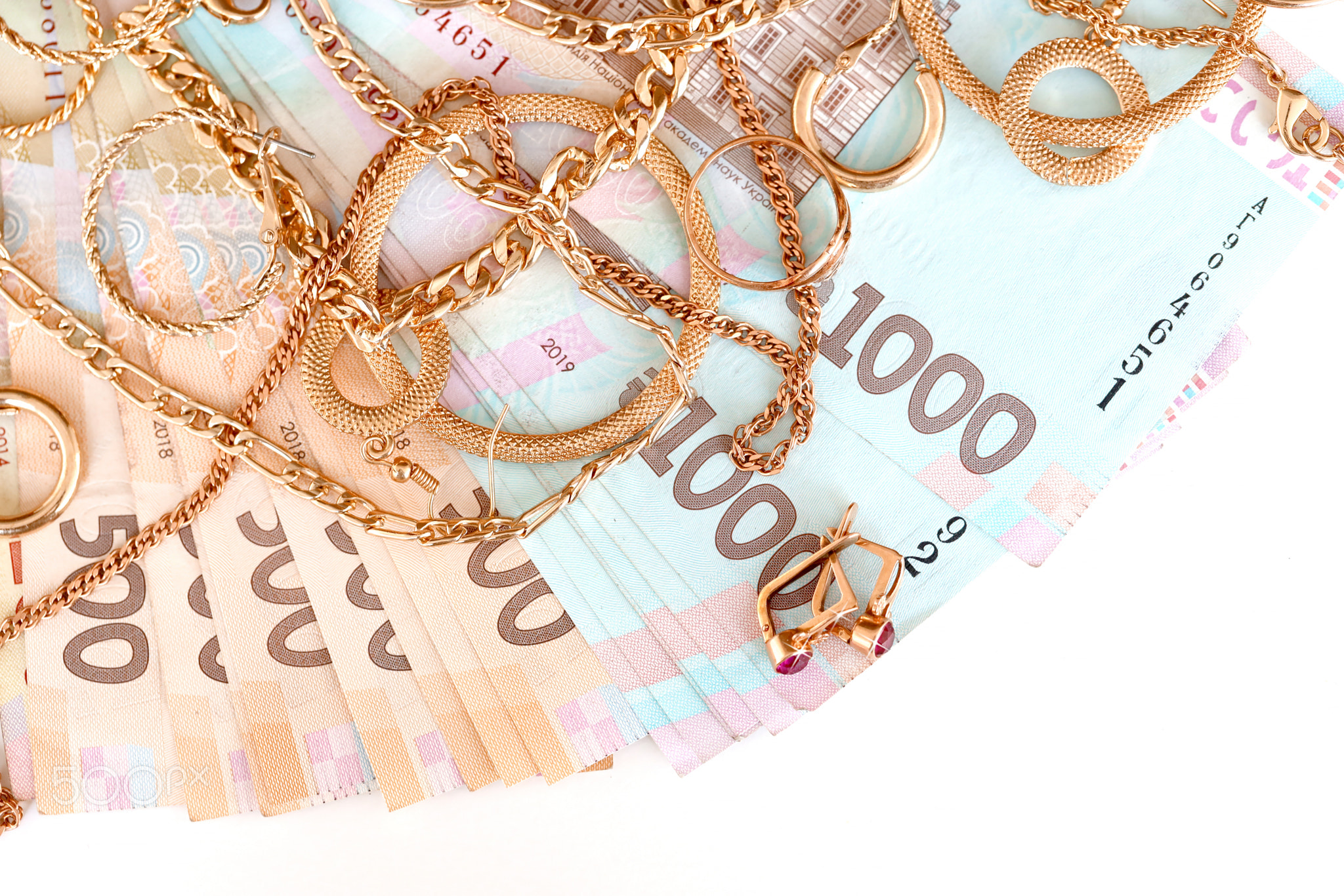 Many expensive golden jewerly rings, earrings and necklaces with big amount of Ukrainian money bills