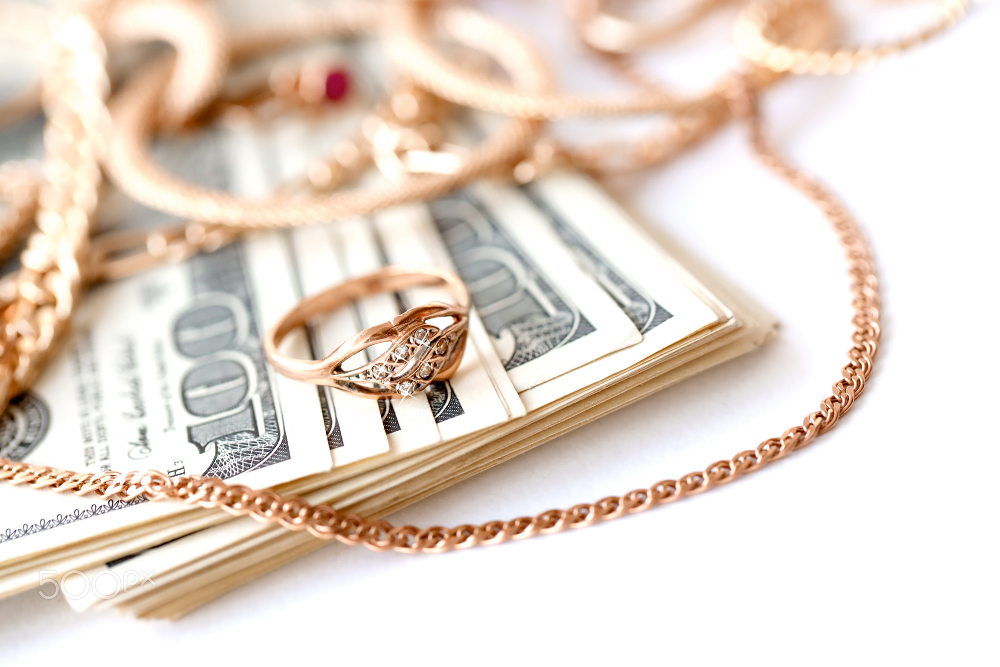 Many expensive golden jewerly rings, earrings and necklaces with big amount of US dollar bills on