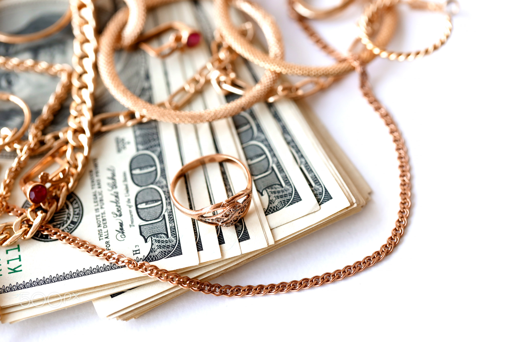 Many expensive golden jewerly rings, earrings and necklaces with big amount of US dollar bills on