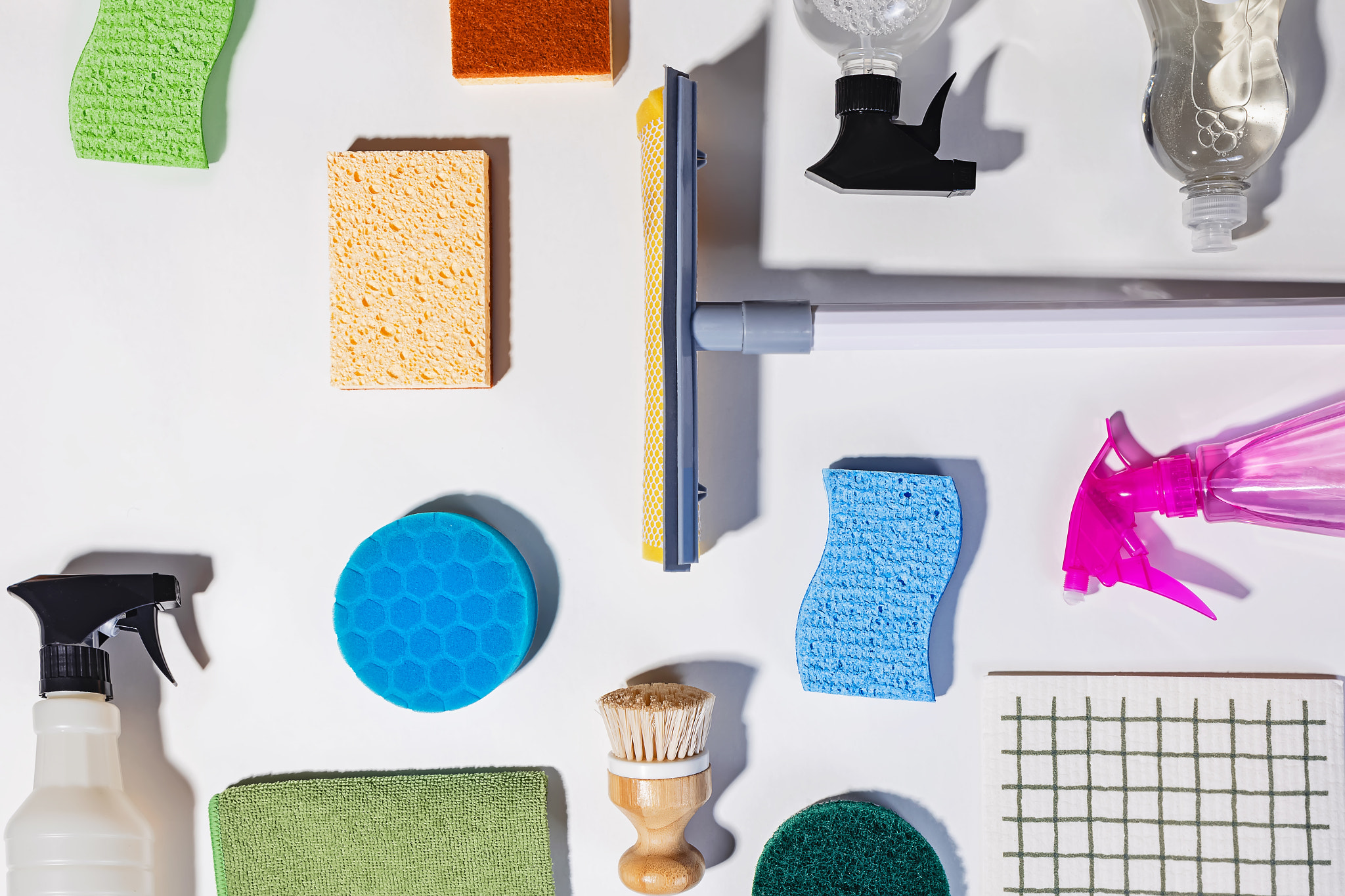 Various cleaning tools and supplies on white background, view from the top. Spring cleaning concept