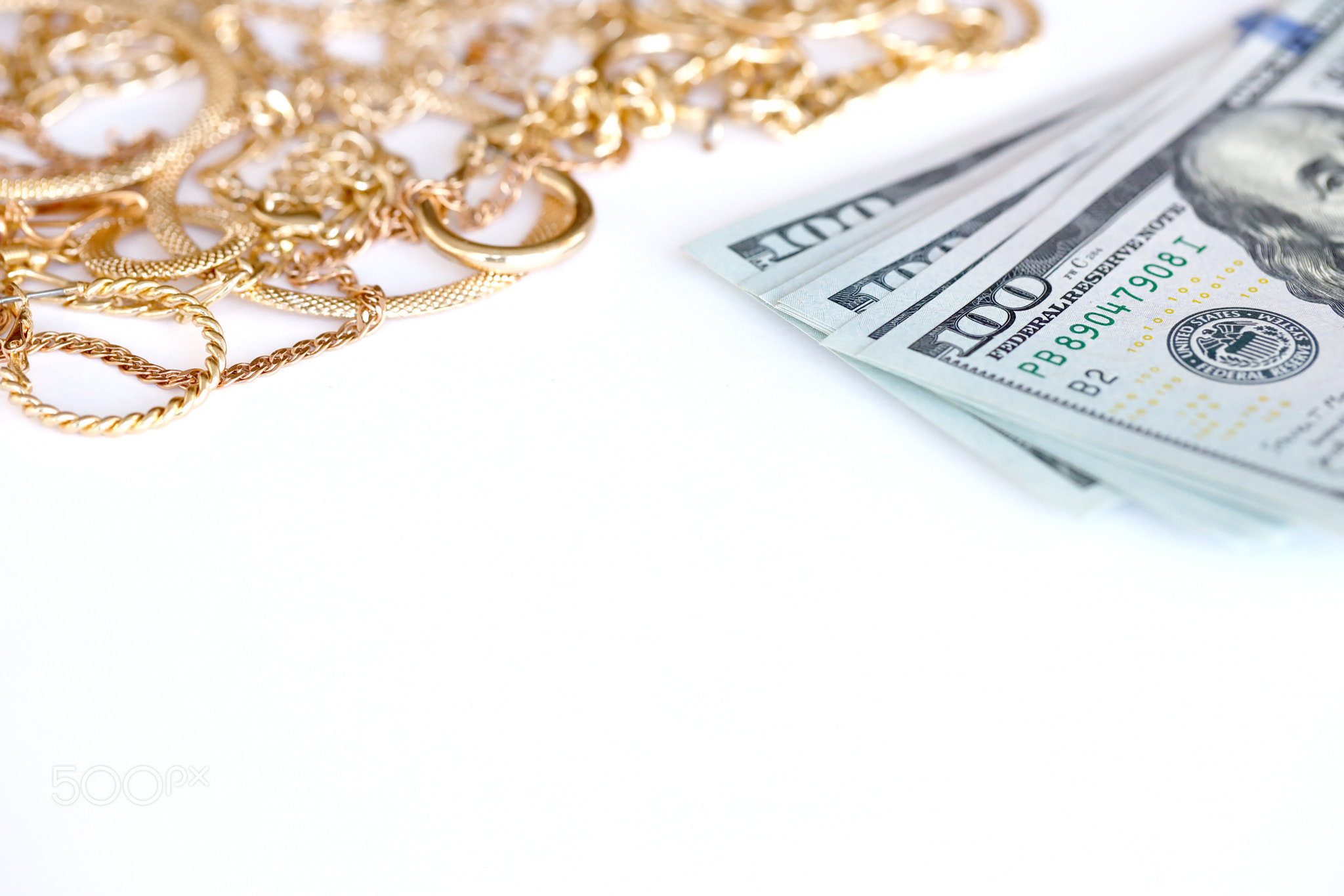 Many expensive golden jewerly rings, earrings and necklaces with big amount of US dollar bills on