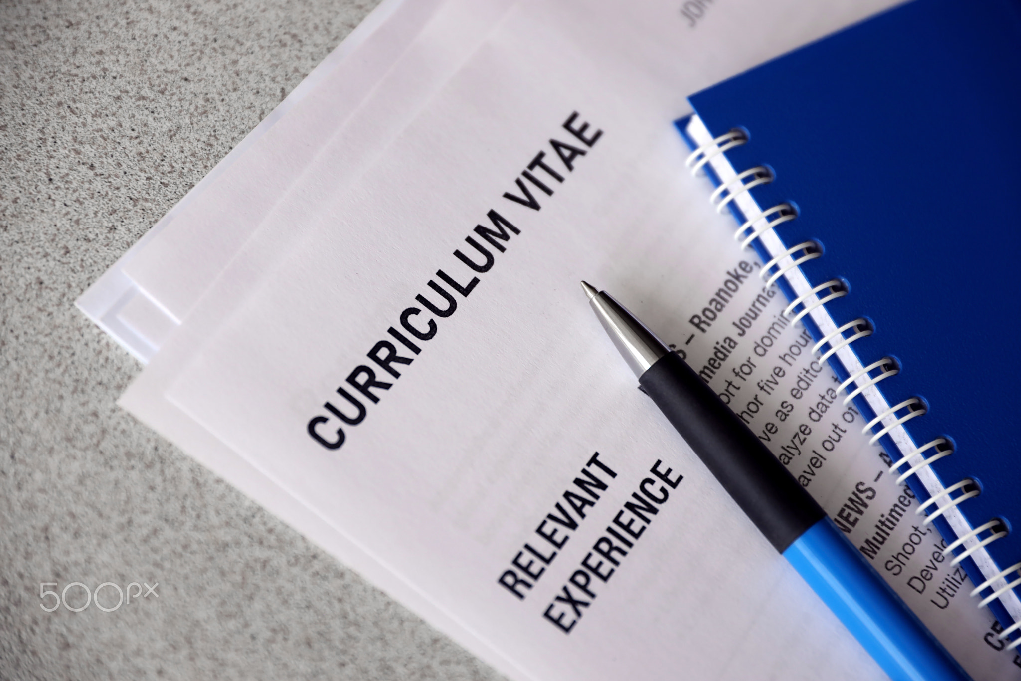 Top view of stack of office documents including resume and cv forms on the desk close to pen and