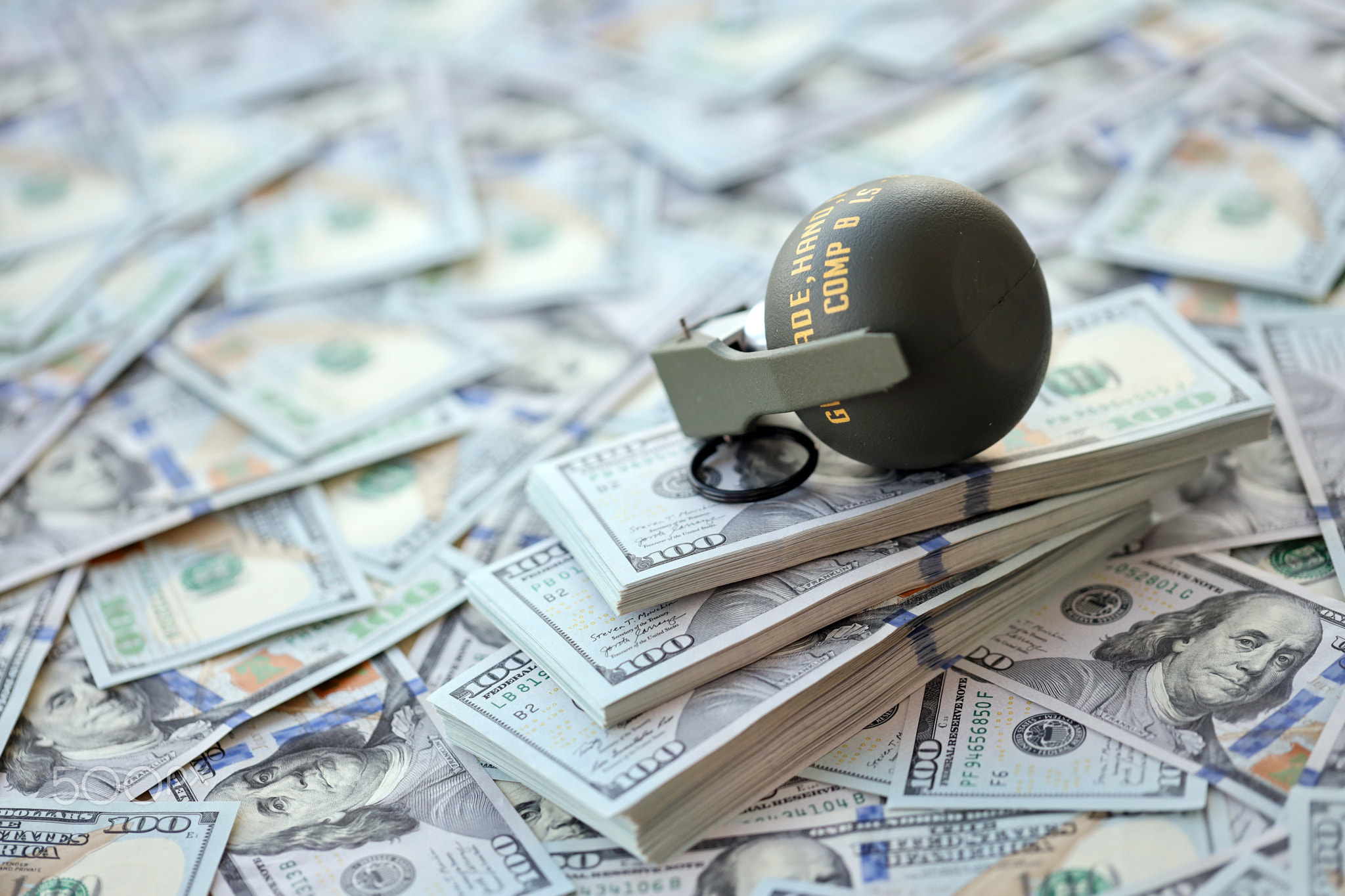 Grenade with a check against the background of huge amount of american dollar bills