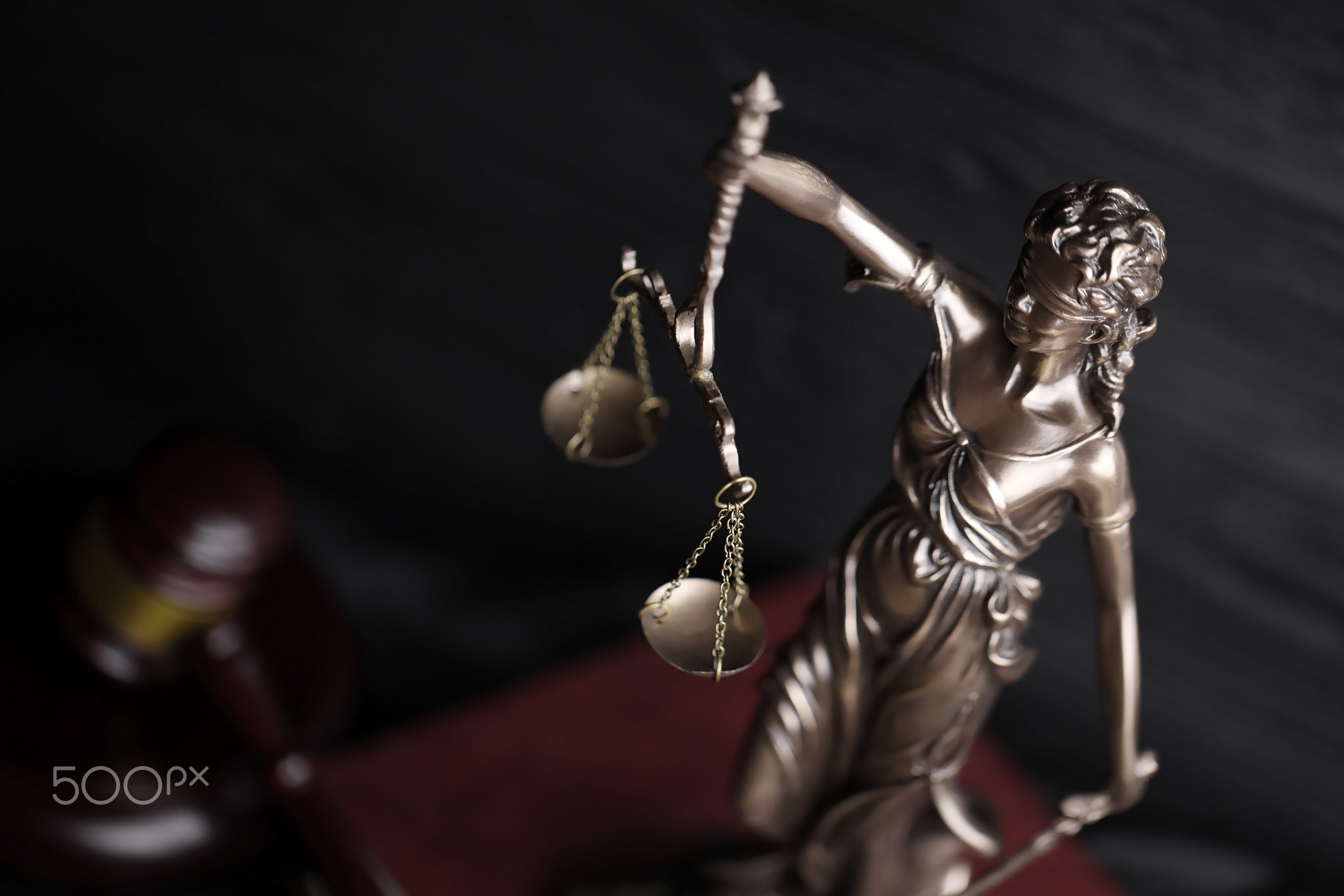 The Statue of Justice - lady justice or justitia the Roman goddess of Justice. Statue on brown book