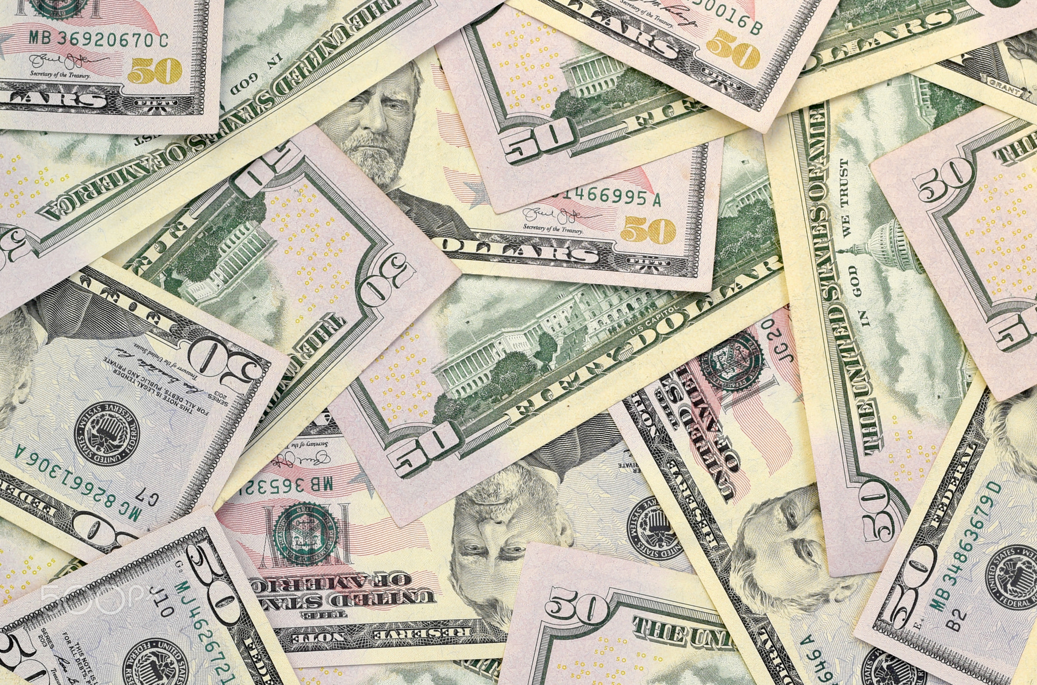 Many US fifty dollar bills on flat background surface close up. Flat lay top view. Abstract business