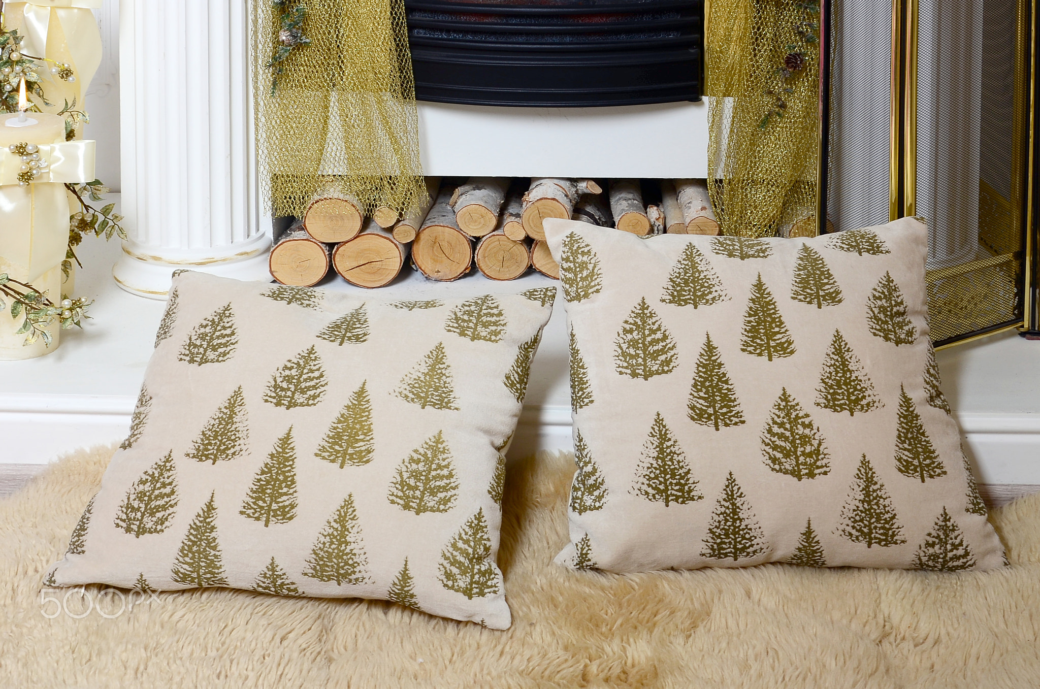 A pair of beige pillows lie on a soft plush veil near the fireplace