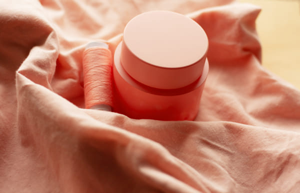 jar of cream and sawing threads in color peach fuzz by Sabina Eivazova on 500px.com