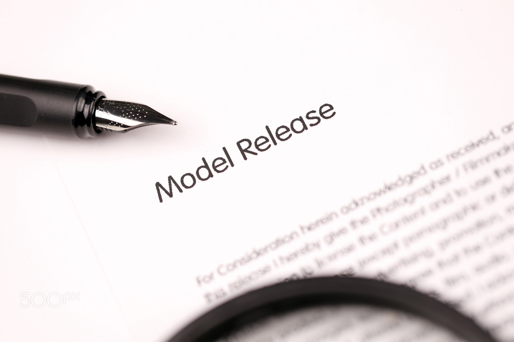 Model Release on A4 tablet lies on office table with pen and magnifying glass