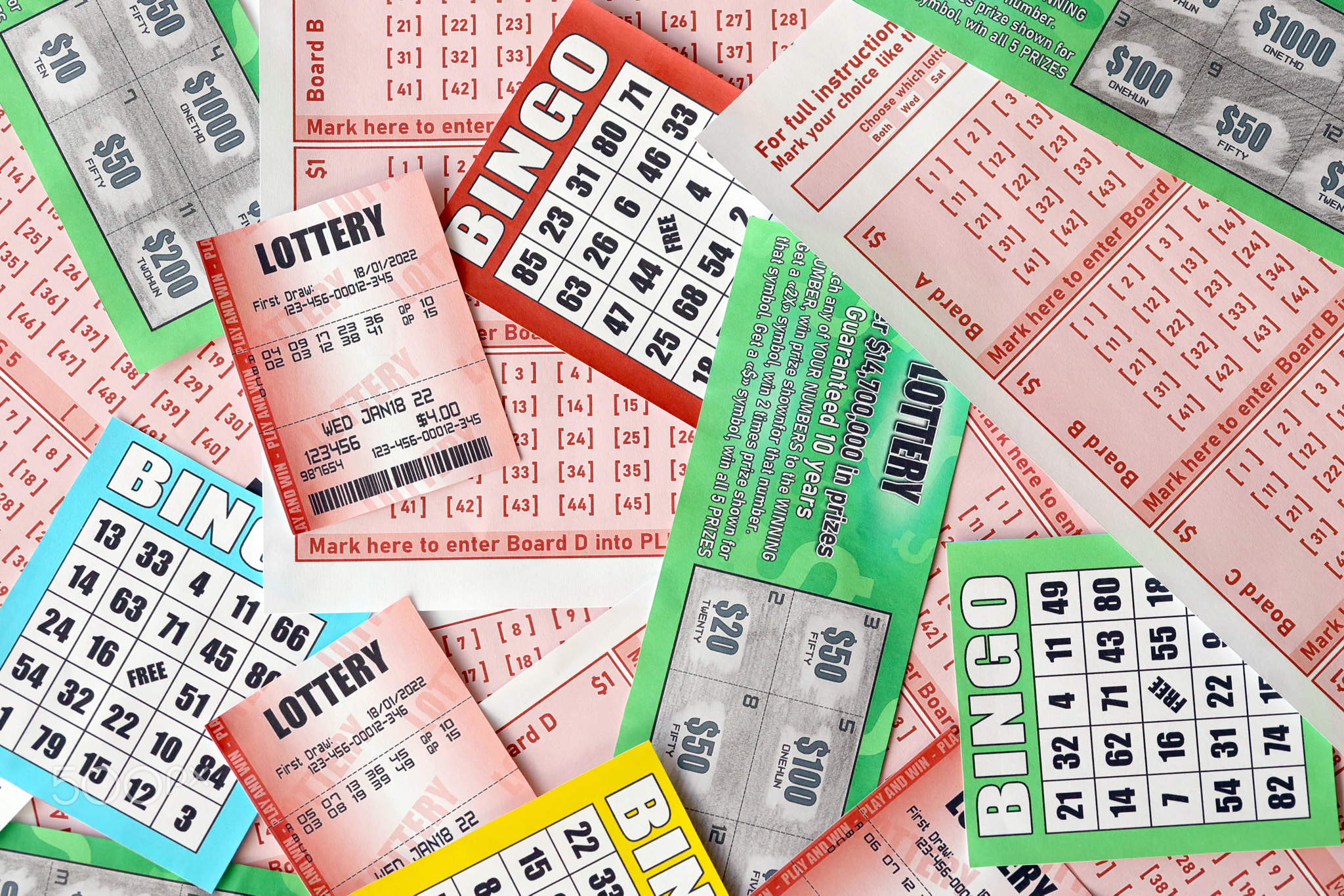Many used lottery tickets, bills with numbers and bingo playing boards in big pile. Gambling and