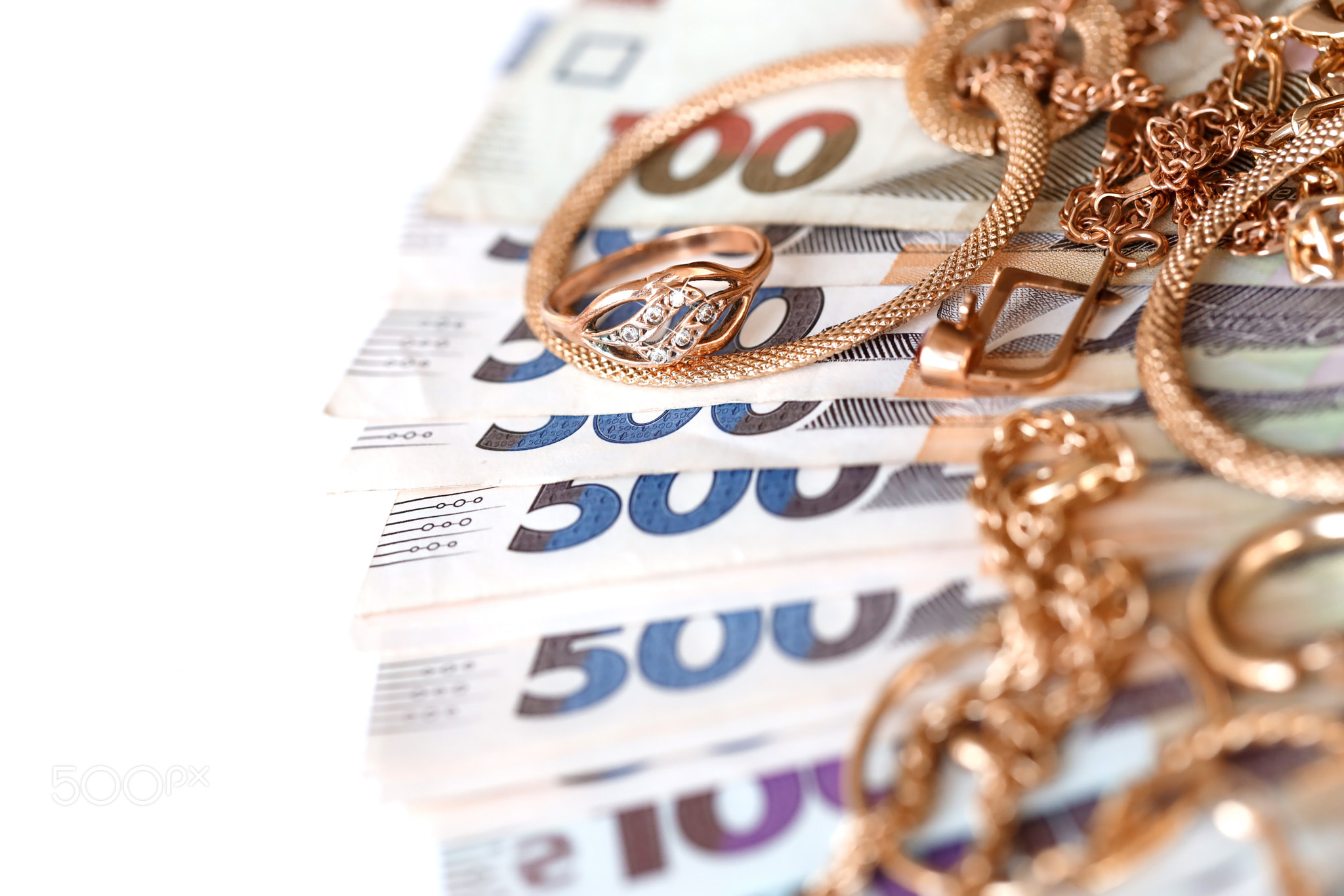 Many expensive golden jewerly rings, earrings and necklaces with big amount of Ukrainian money bills