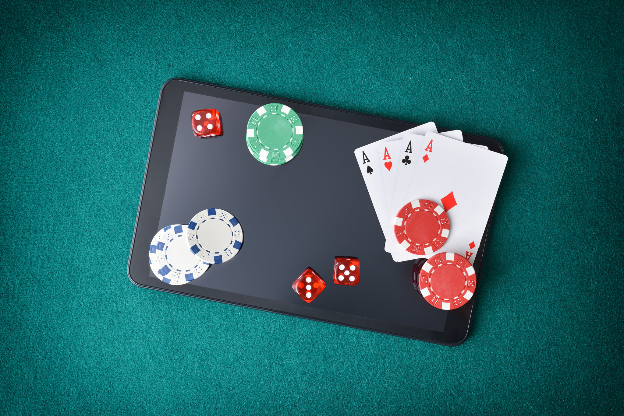 Online casino games with objects on tablet on green mat
