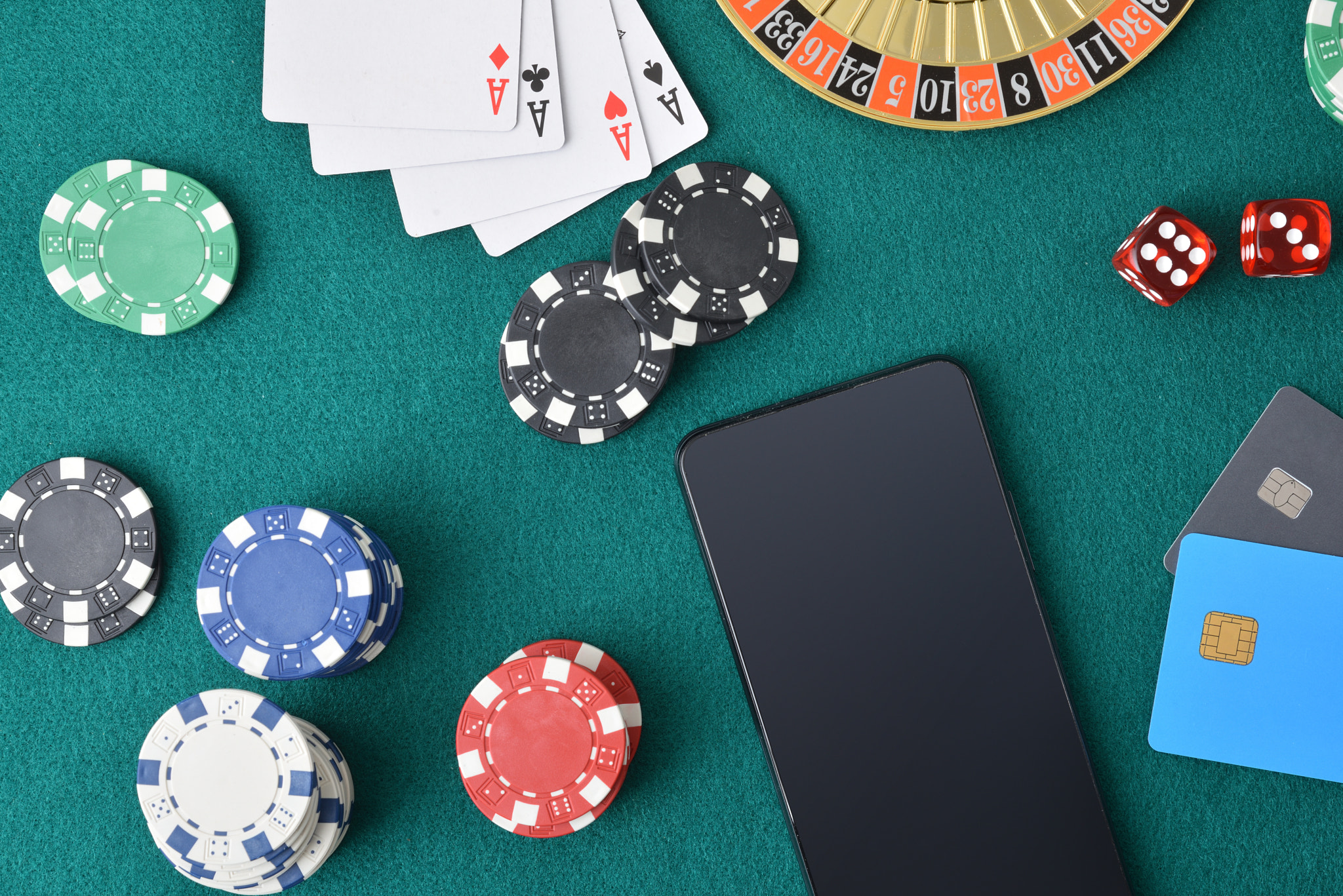 Online casino games with smartphone on mat with bank cards