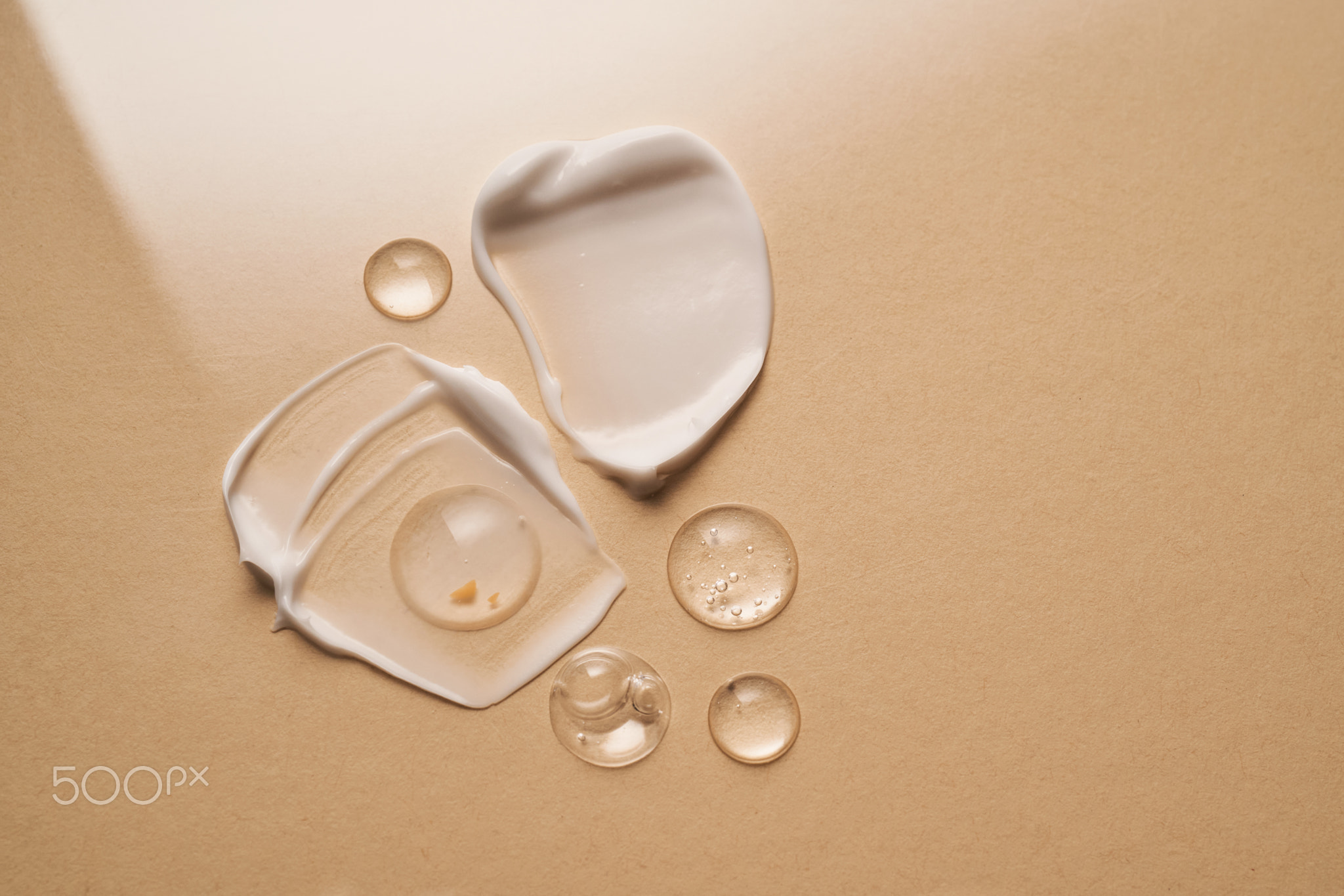 Gel, serum and a cream on a a beige background.