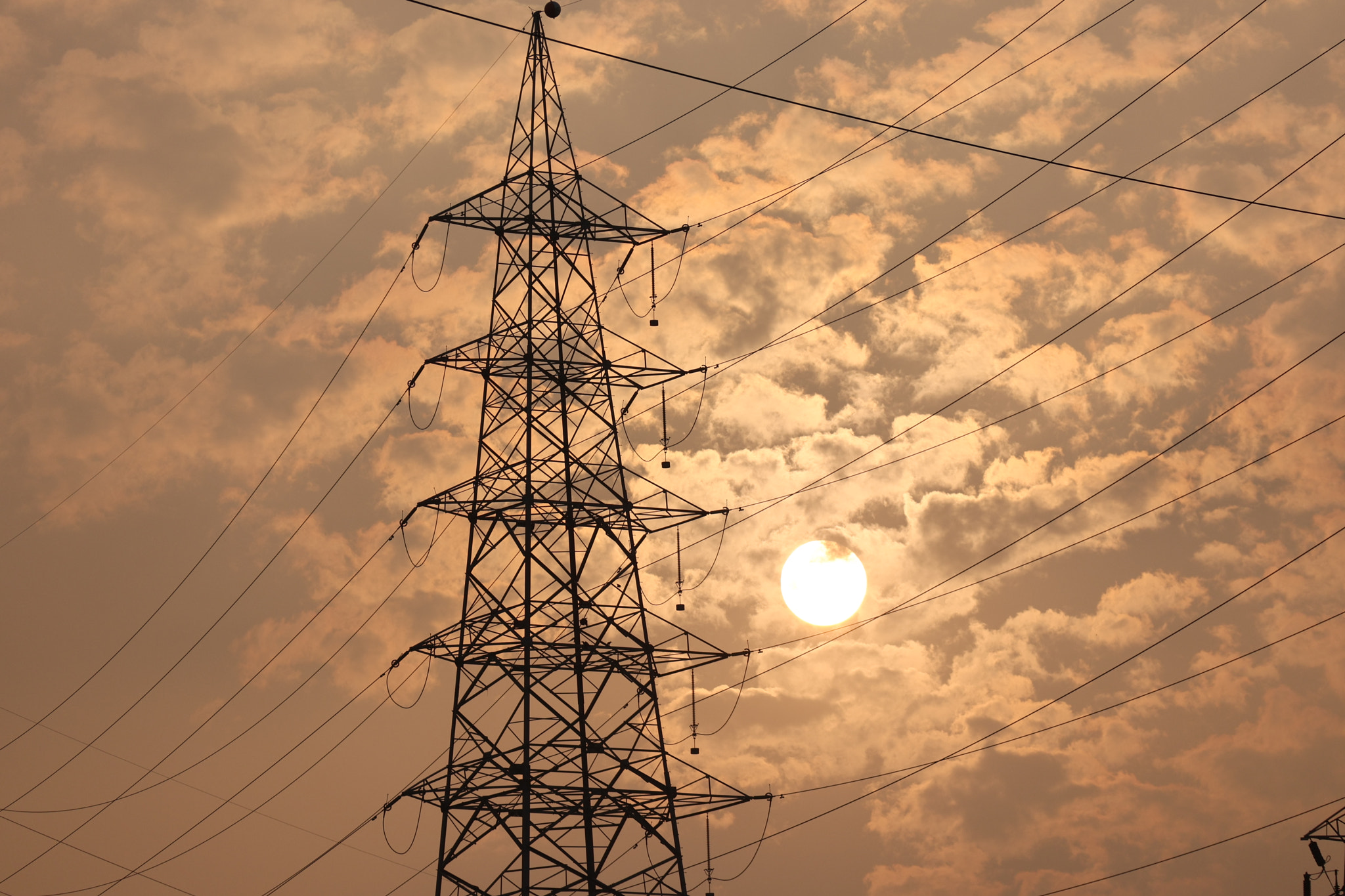 Low angle view of electricity pylon against sky during sunset