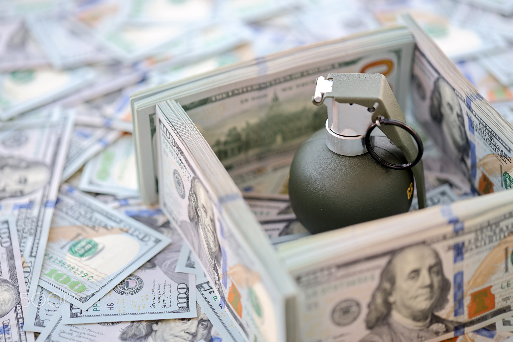 Grenade with a check against the background of huge amount of american dollar bills