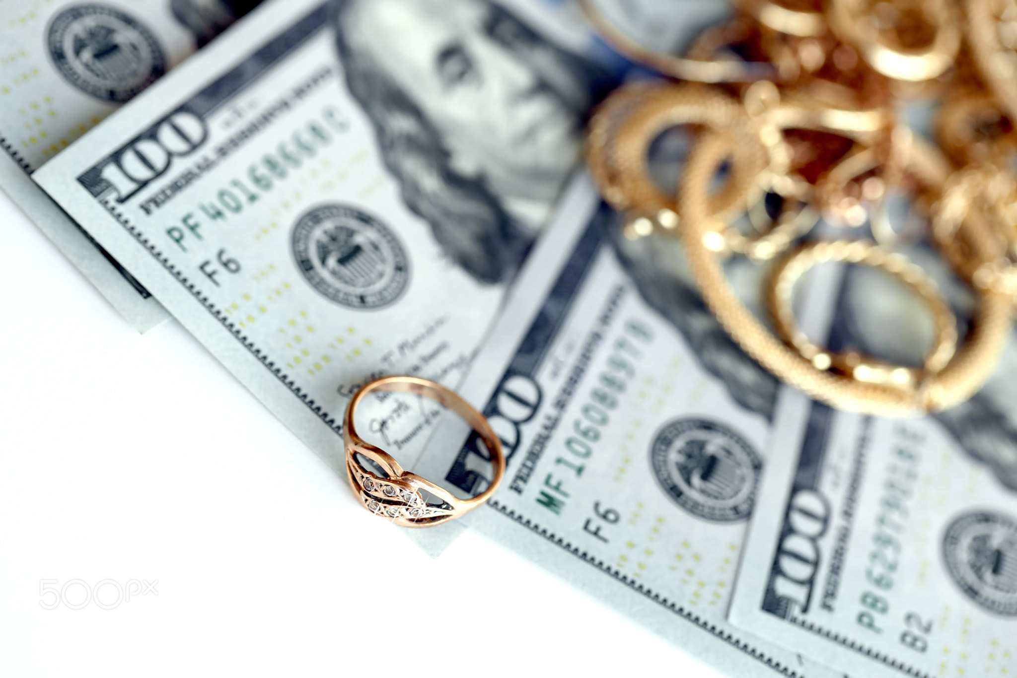 Many expensive golden jewerly rings, earrings and necklaces with big amount of US dollar bills on