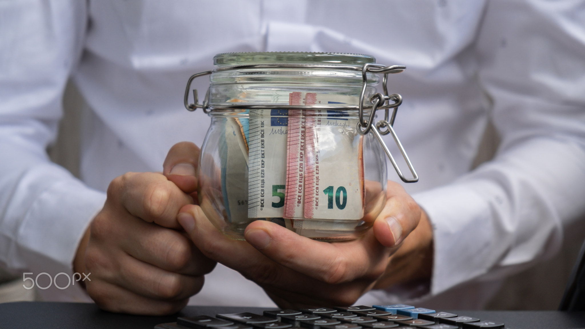 Euro Banknote Saving Money In Glass Jar. Unrecognizable man Moderate