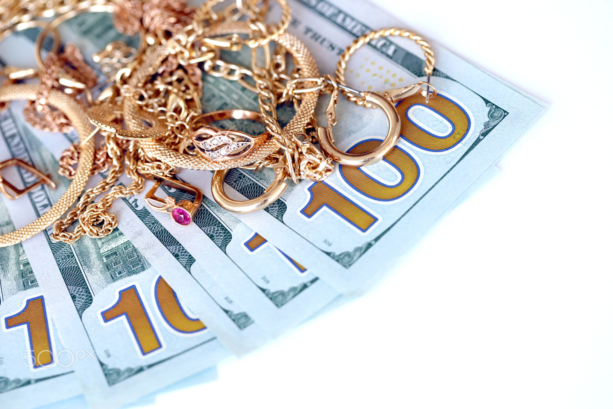 Many expensive golden jewerly rings, earrings and necklaces with big amount of US dollar bills on