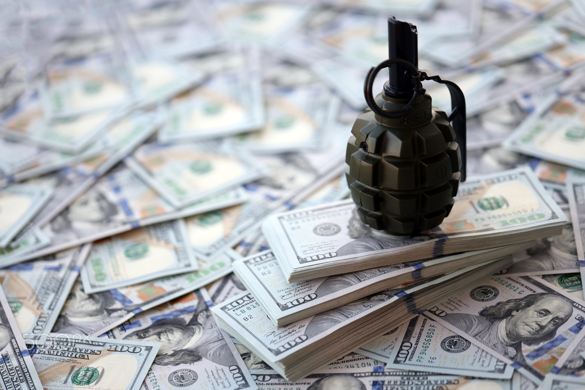 Grenade with a check against the background of huge amount of american dollar bills