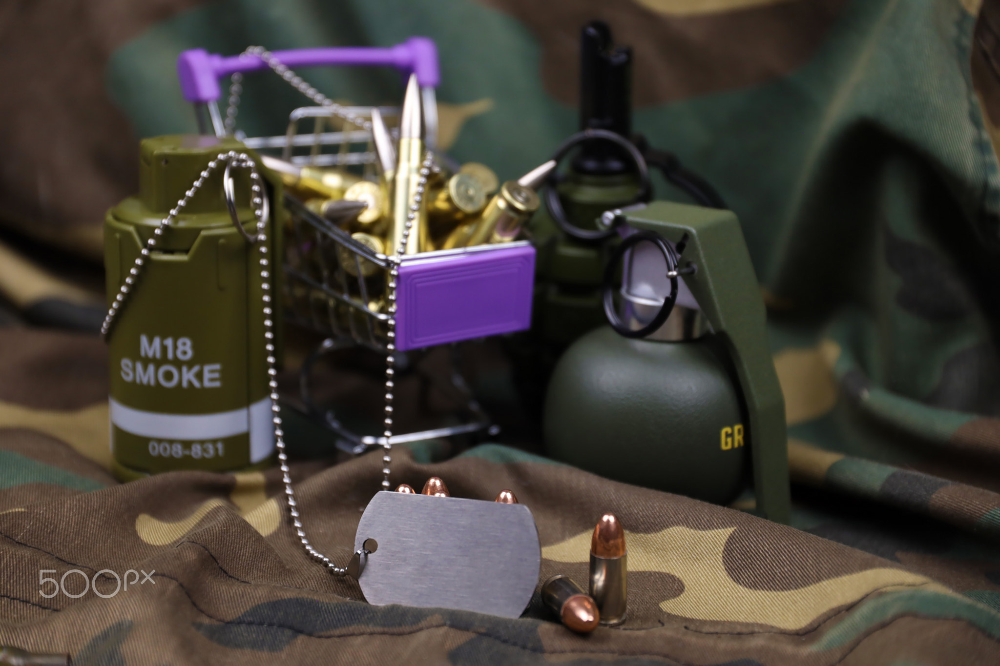 Rifle cartridges in small shopping cart. Big caliber ammo cartridges and hand grenades with a small