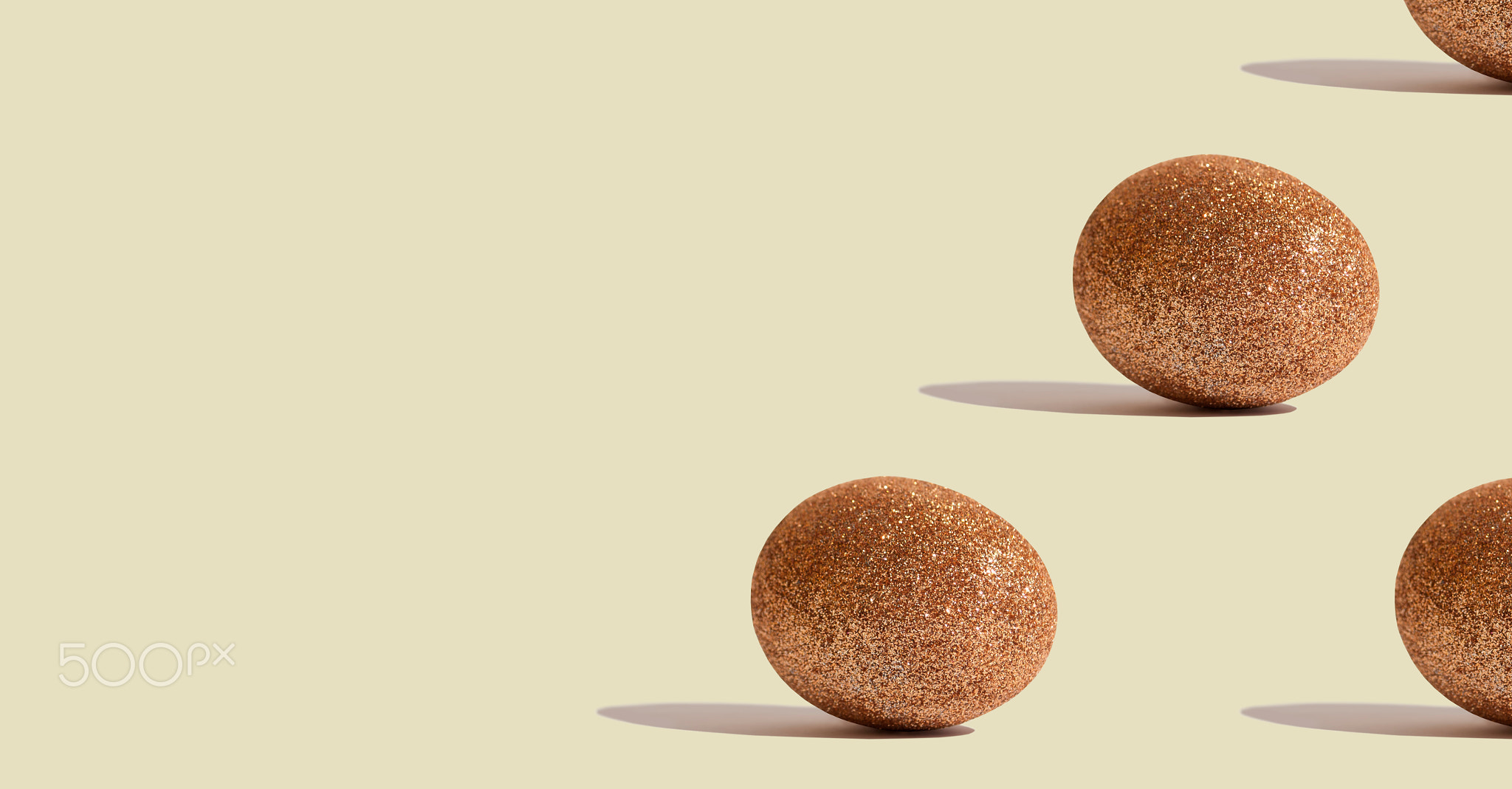 Glitter gold eggs on beige background