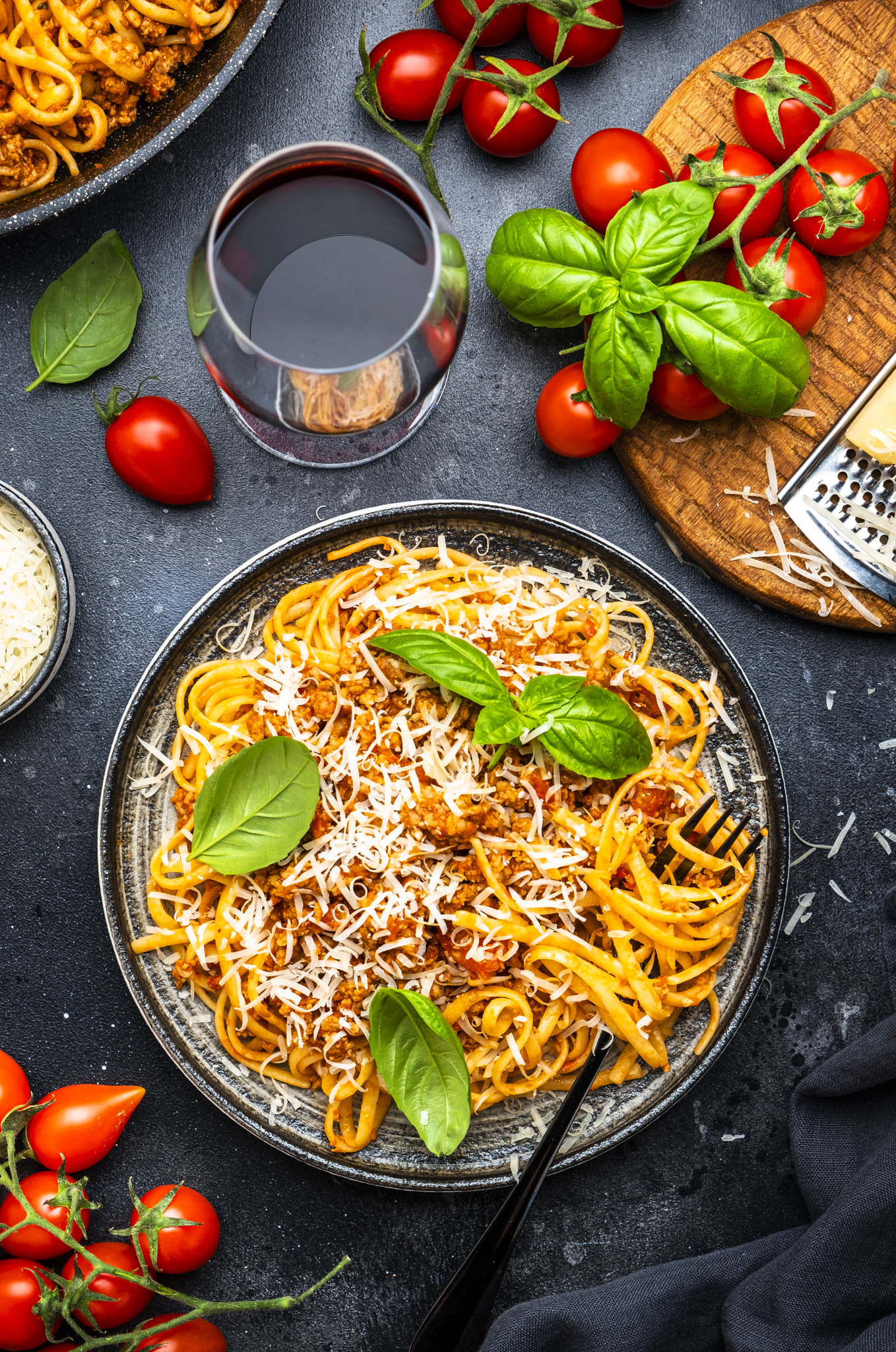 Spaghetti bolognese or pasta with minced meat in tomato sauce with green basil and chianti red wine