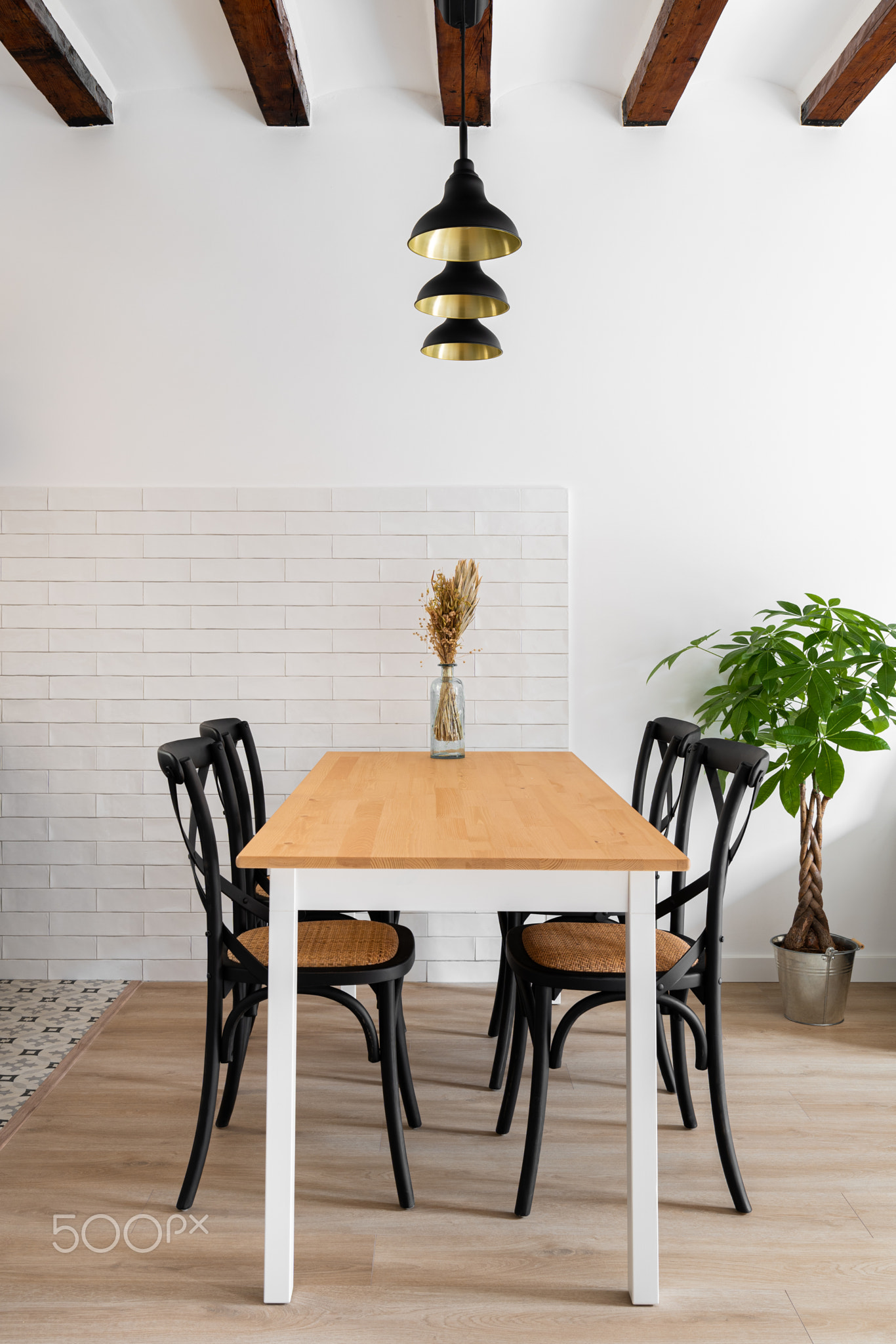 Vertical frame wooden dining table with four designer chairs with lamps and wooden beams on the