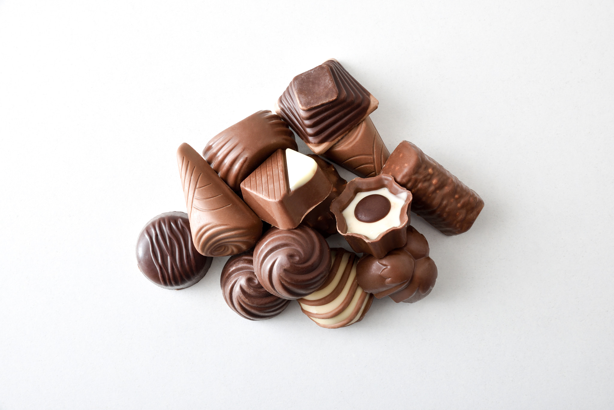 Assortment with stack of chocolates isolated on white top view