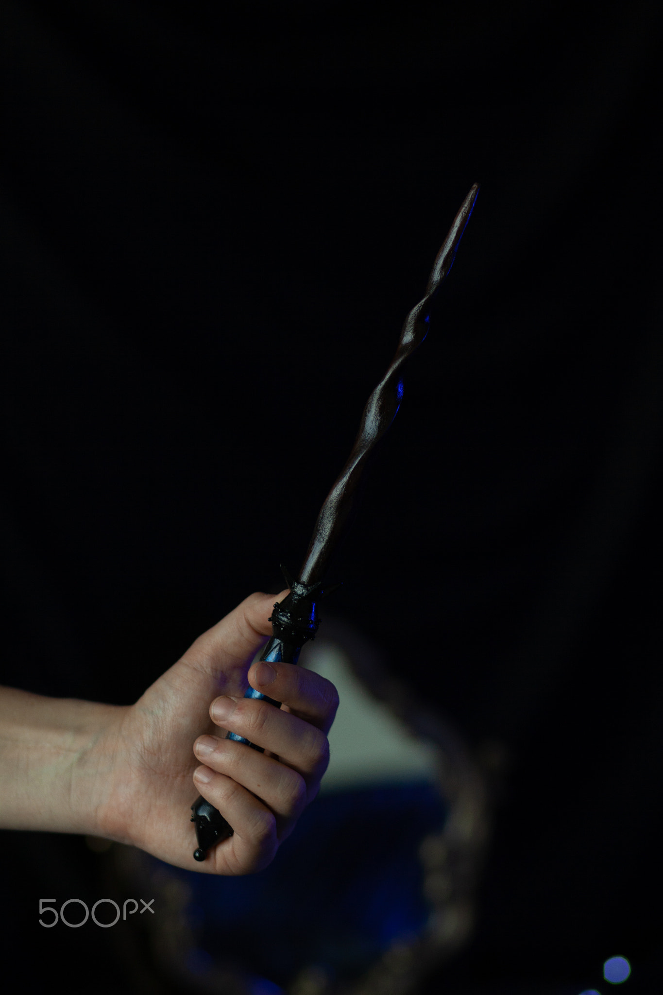 A magician's hand holds a magic wand