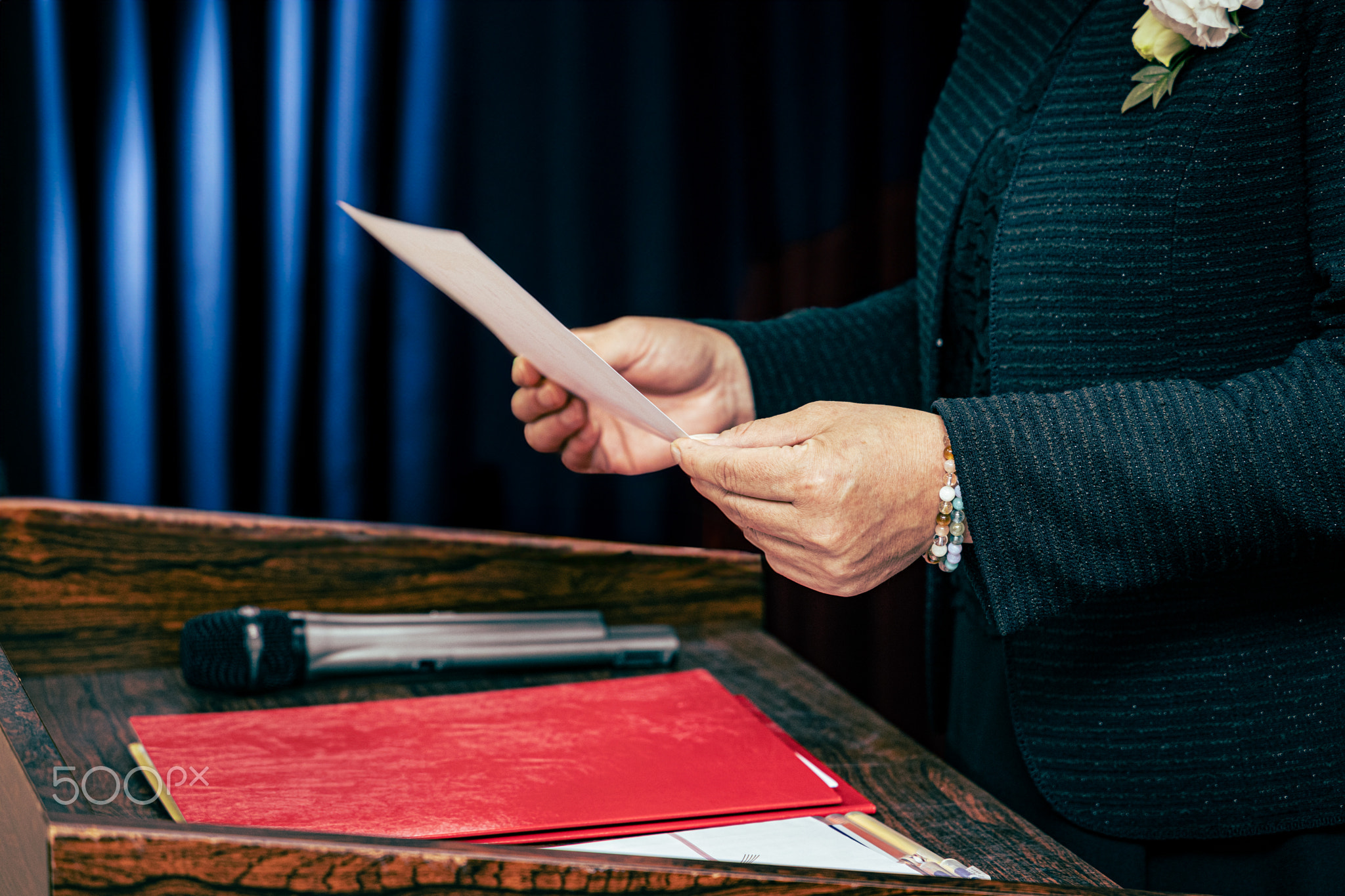 A woman in a suit reads a document at the press conference