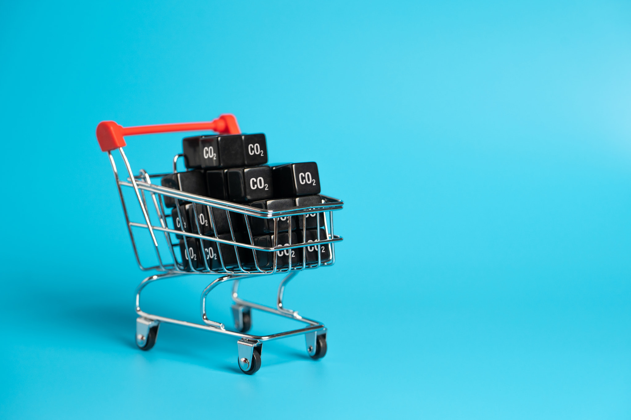 Shopping cart and cubic CO2 carbon dioxide. Greenhouse gas consumption and footprint. Calculate the 
