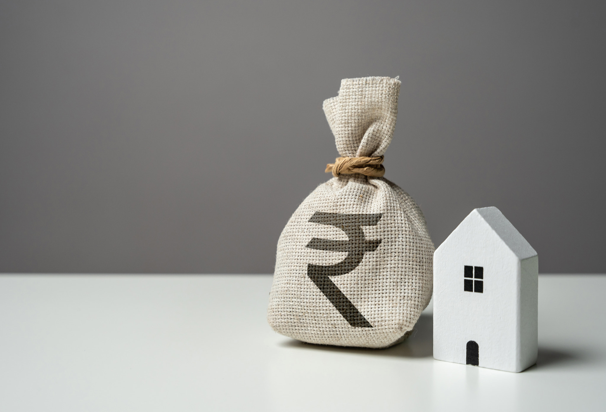 House and indian rupee money bag. Investments in the purchase of real estate. Repair and service. Ma