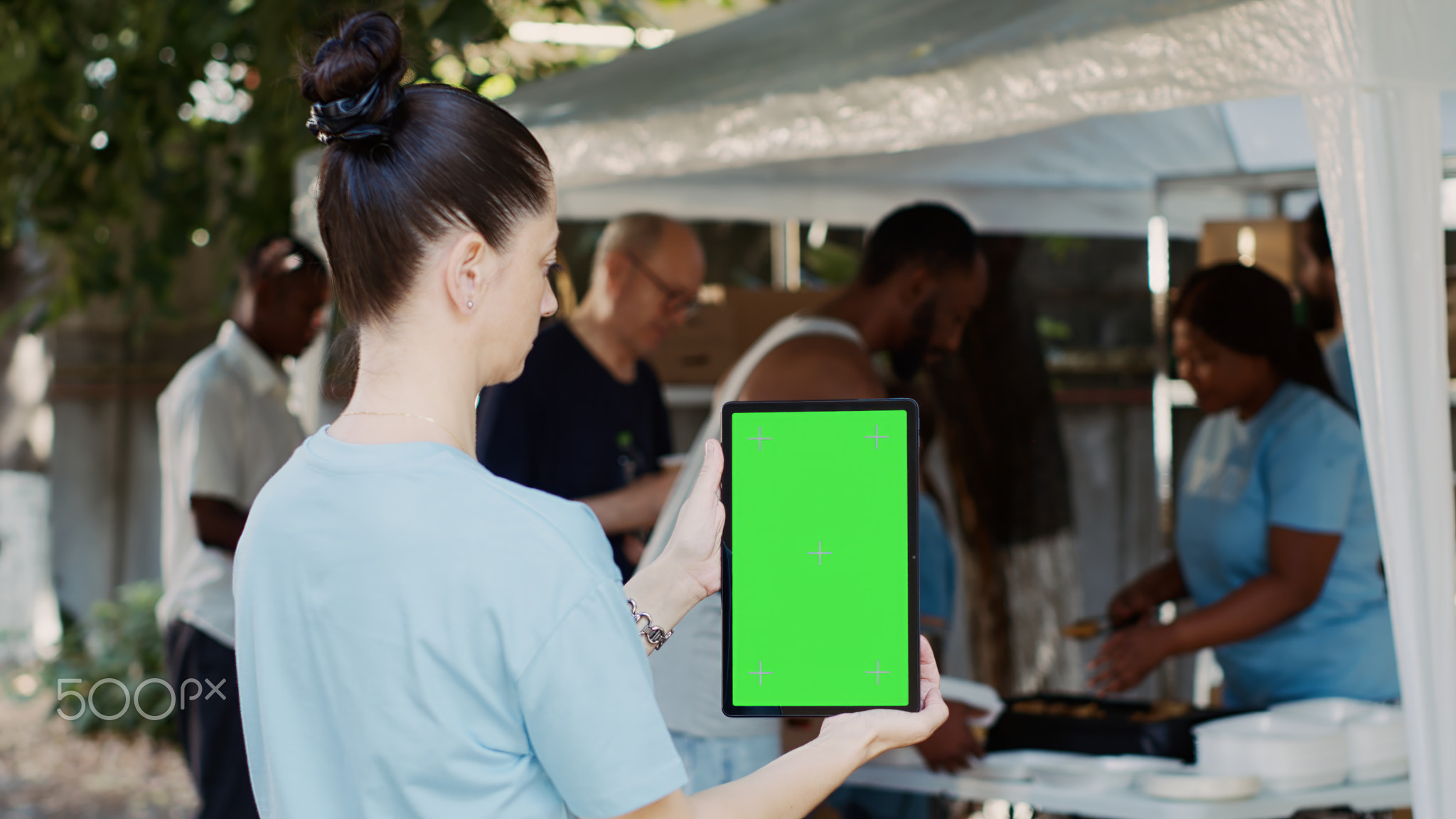 Device with green screen held by woman