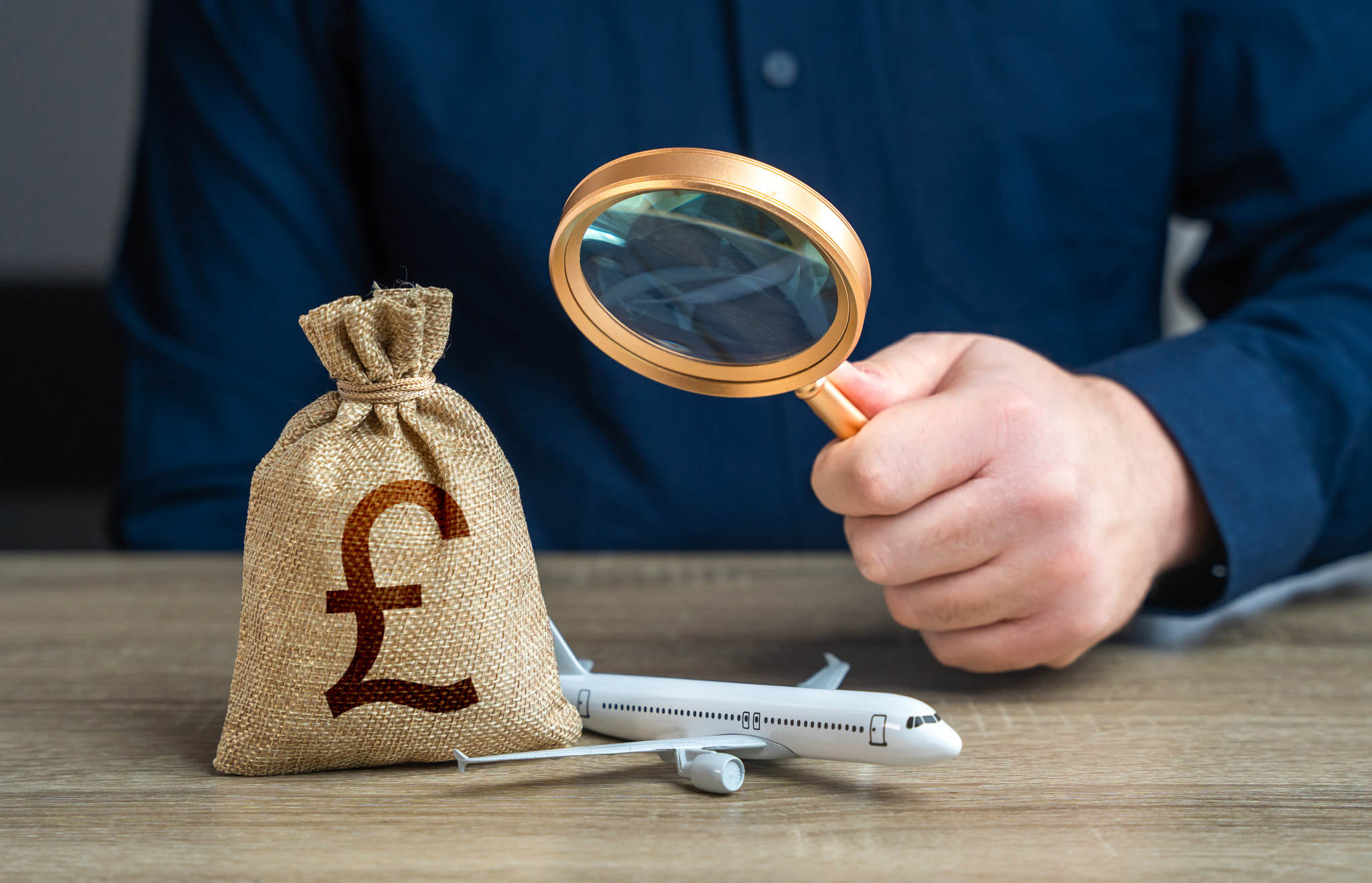 Monitoring the payment of taxes in the aviation industry and british pound sterling money bag. Budge