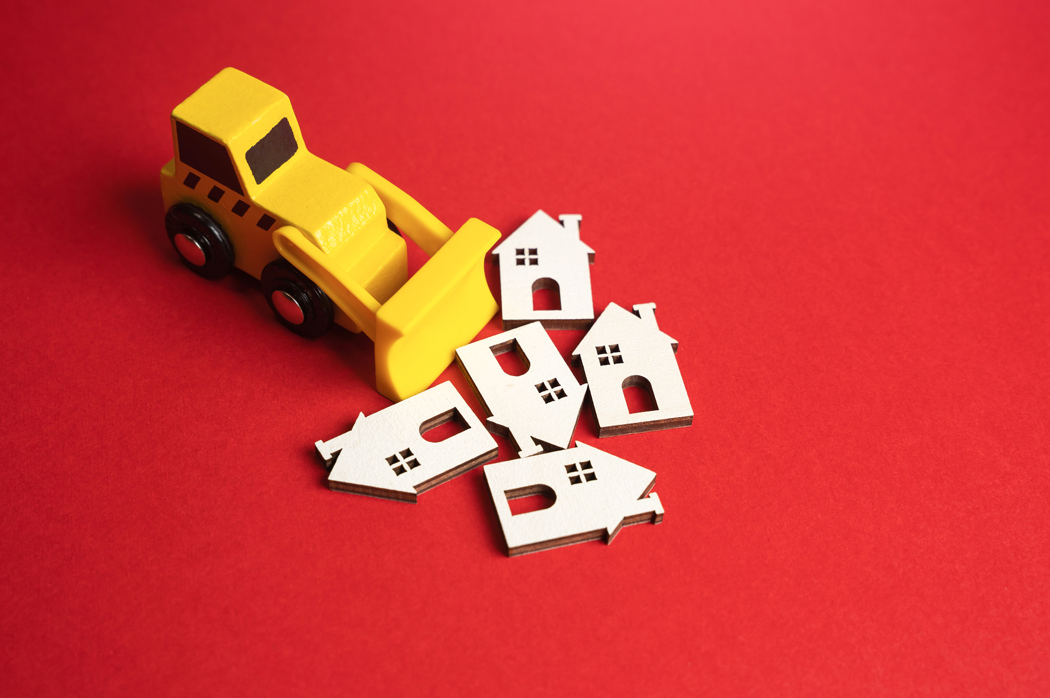 Cleaning up the real estate market. Yellow bulldozer demolishes houses. Demolition of illegal and un