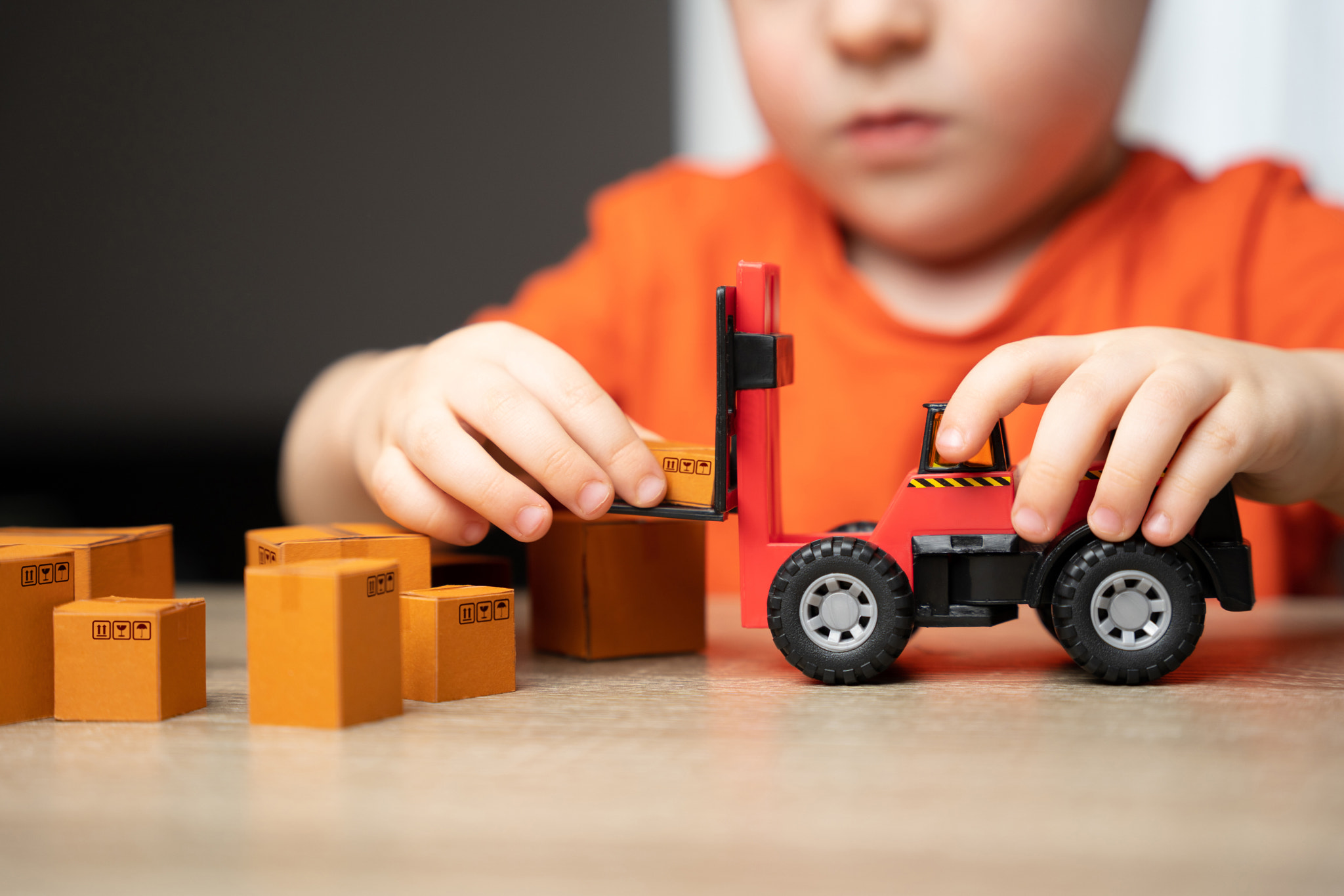 A child plays in loading boxes with a toy forklift. Warehouses, manufacturing facilities, and distri