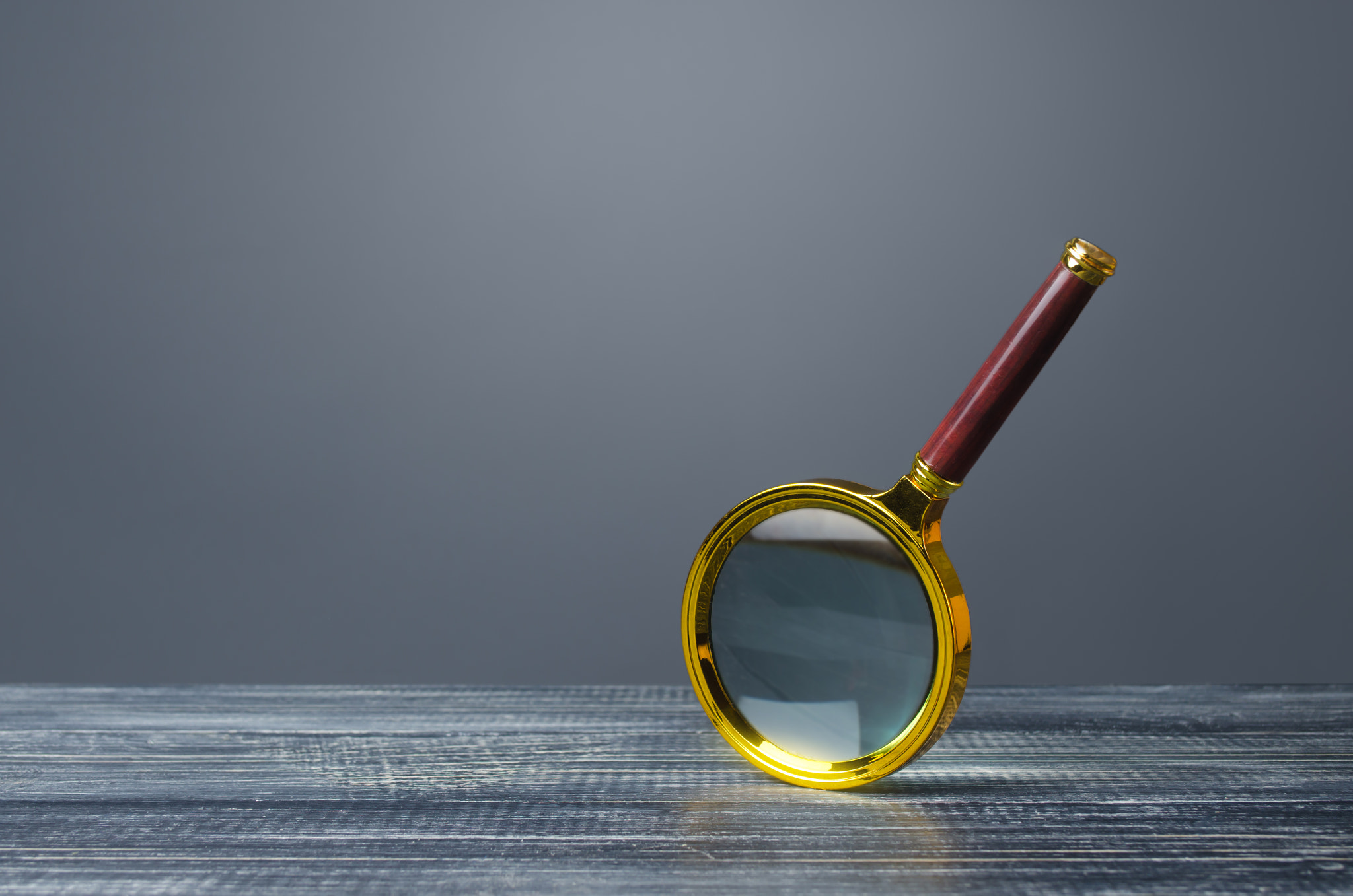 Magnifying glass on a gray background. Search and analysis, analytics and study. Pay attention to de