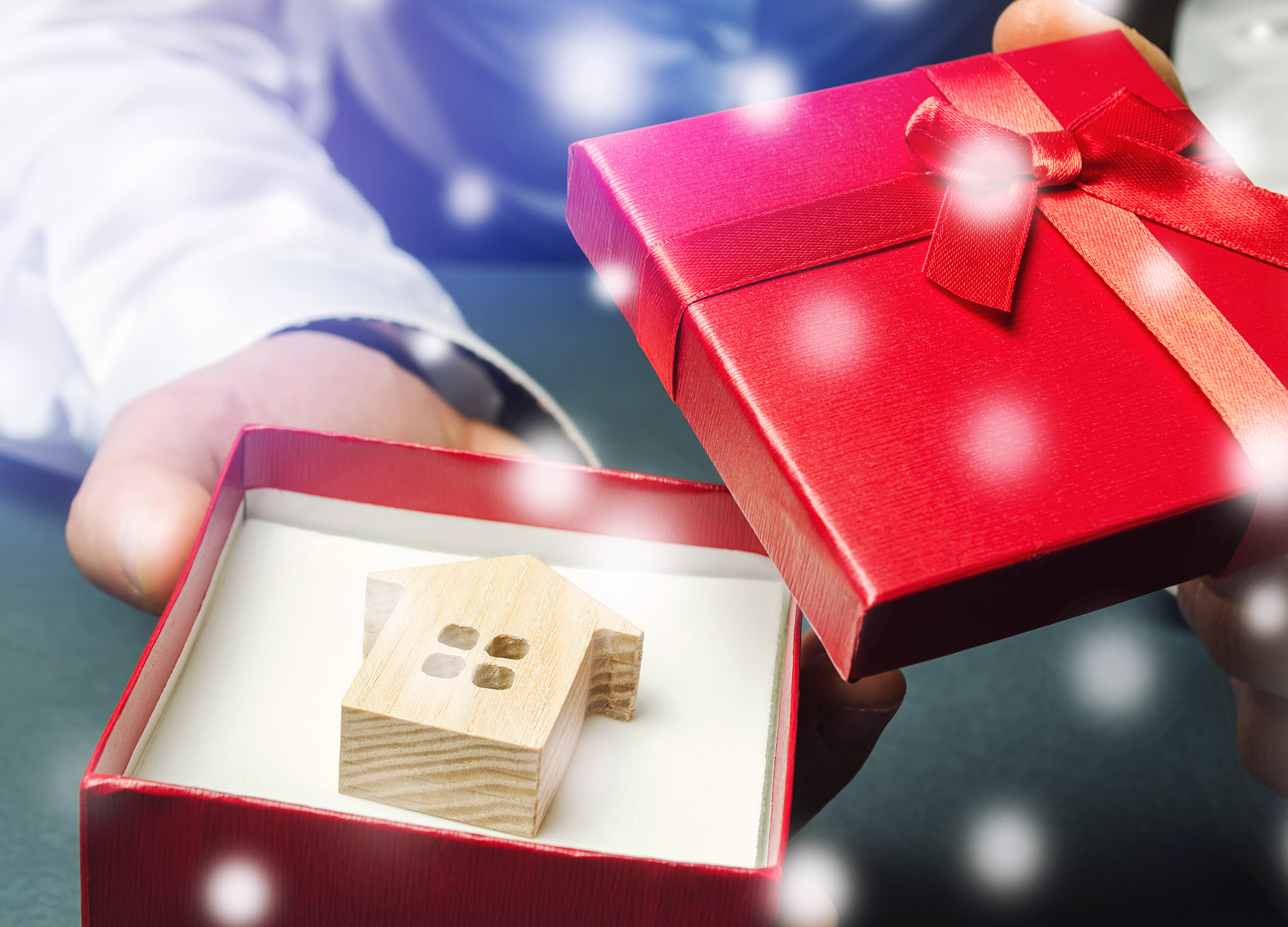 House in a gift box in the hands of a businessman and snow. Great offers for real estate in the wint