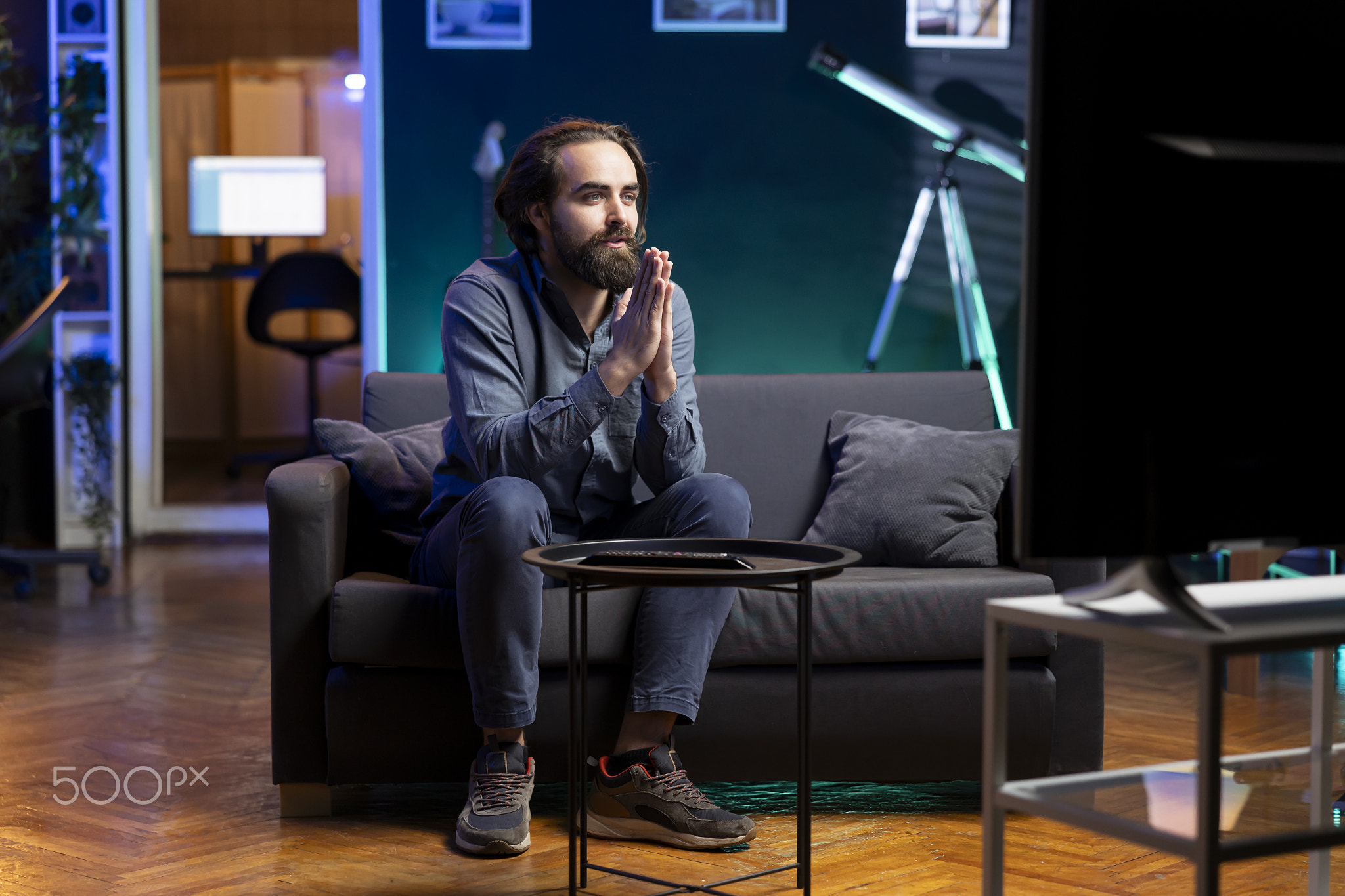 Hopeful man praying for favorite team to win while watching live