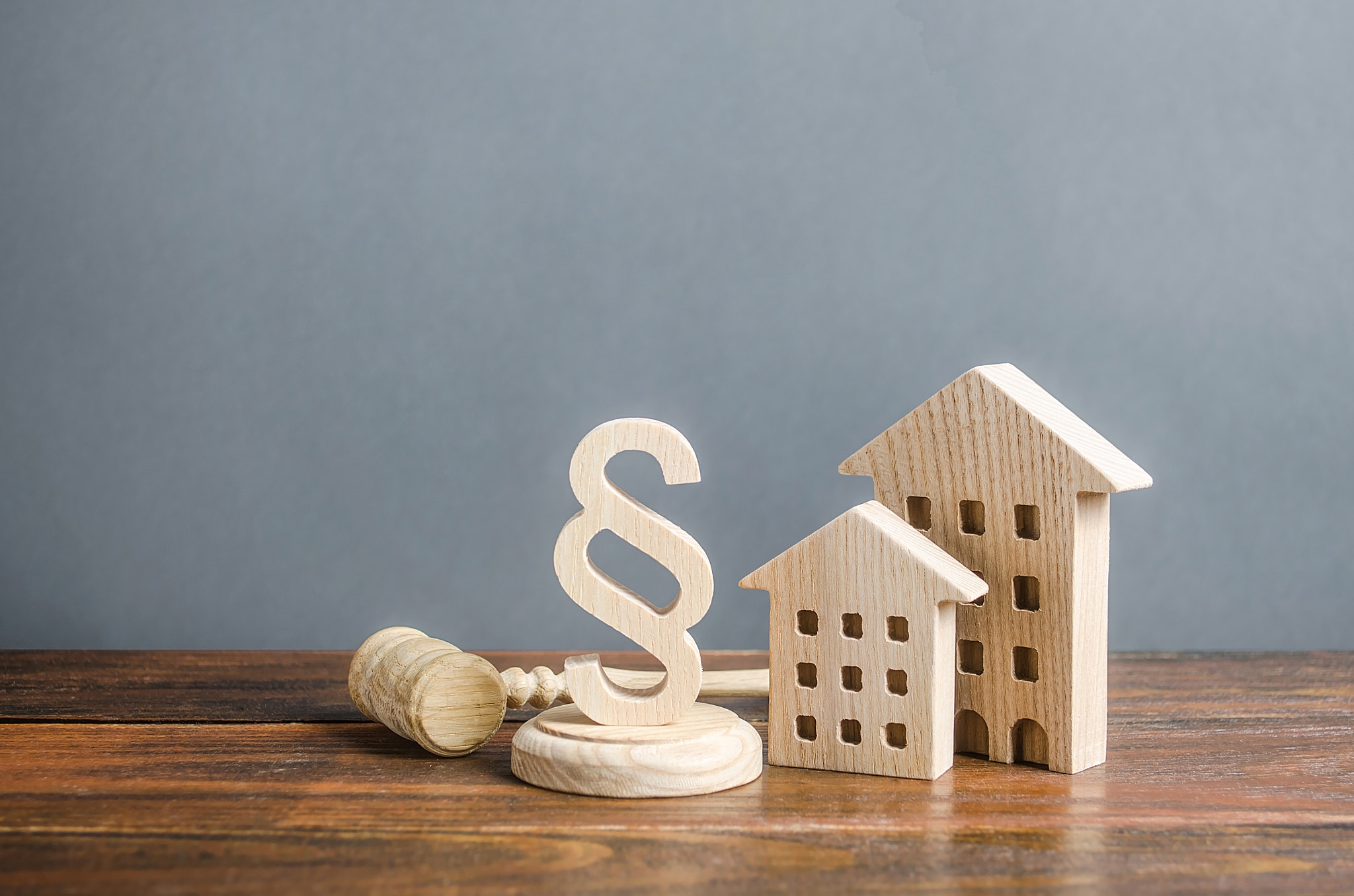 Wooden houses and a paragraph figurine with a judge gavel. Concept legislation on residential buildi