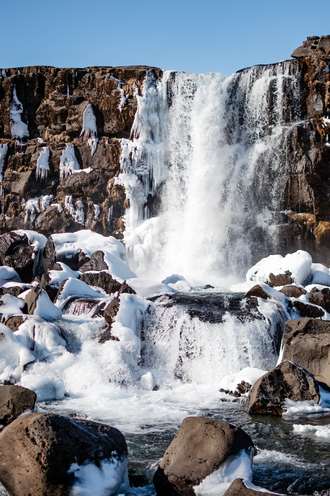 Scenic view of Öxarárfoss waterfall against blue sky during winter time 