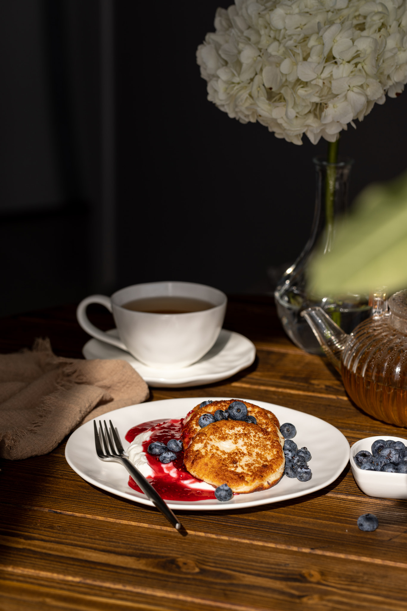 Breakfast with cheesecakes, pancakes with sour cream, mashed berries and fresh blueberries