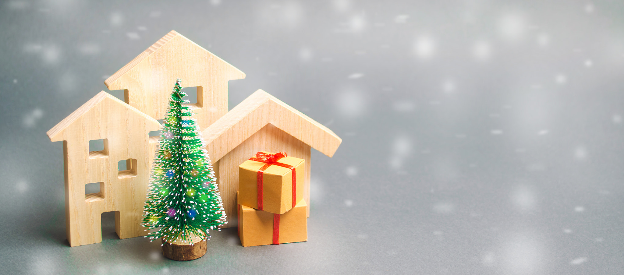 Wooden houses, Christmas tree and gifts. Holiday. Winter vacation. Christmas Sale of Real Estate. Ne