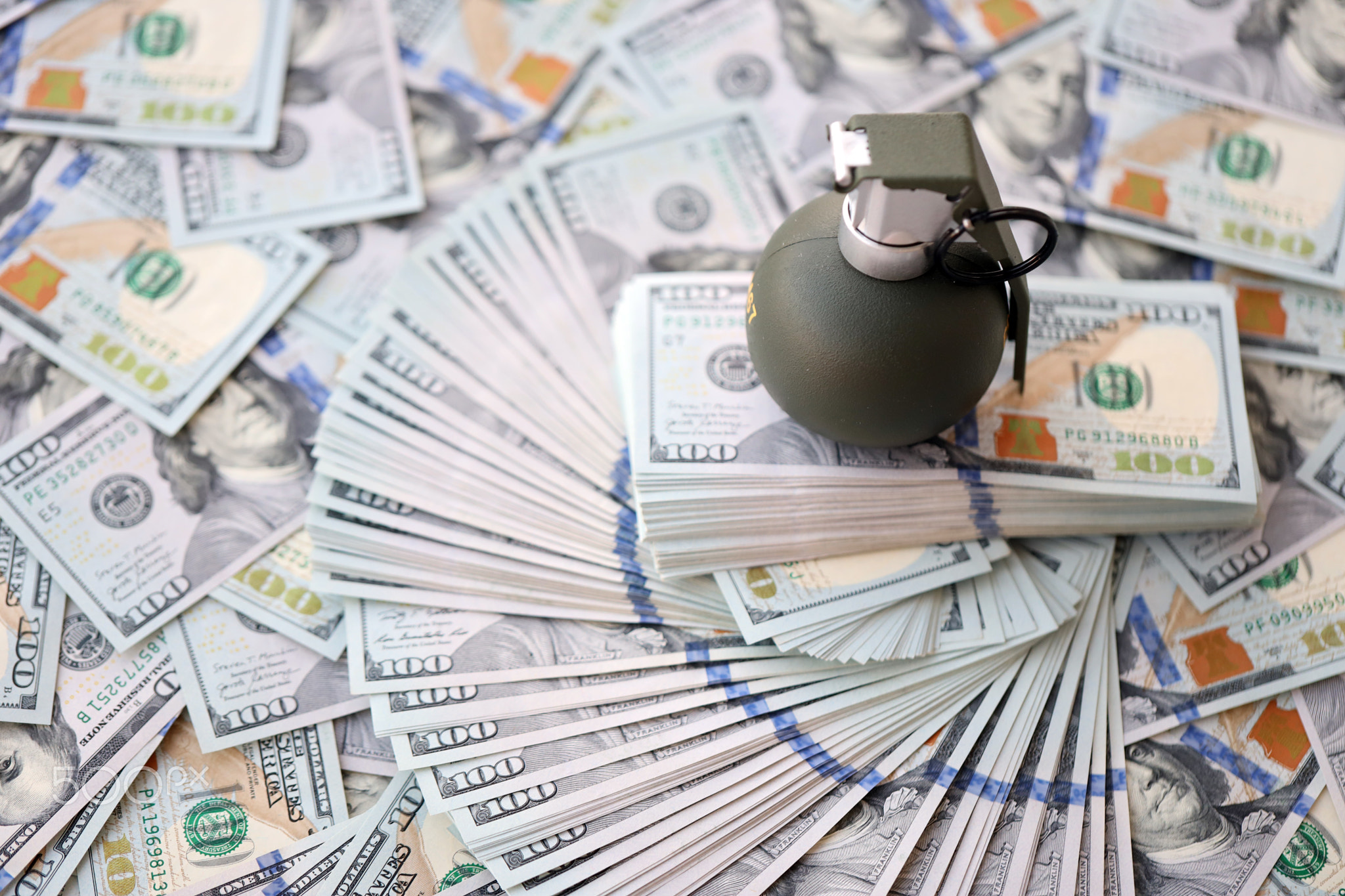 Grenade with a check against the background of huge amount of american dollar bills