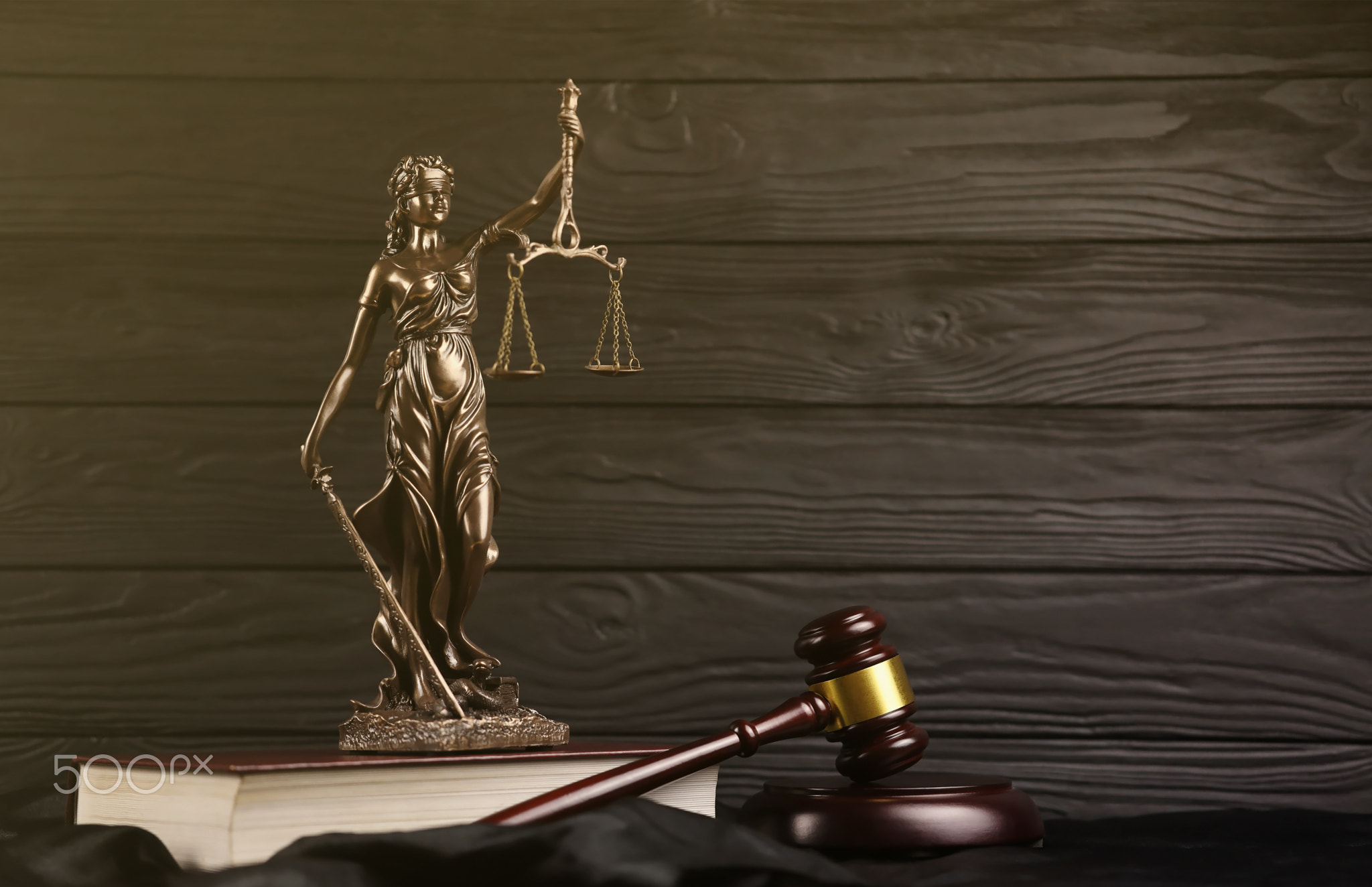 The Statue of Justice - lady justice or justitia the Roman goddess of Justice. Statue on brown book