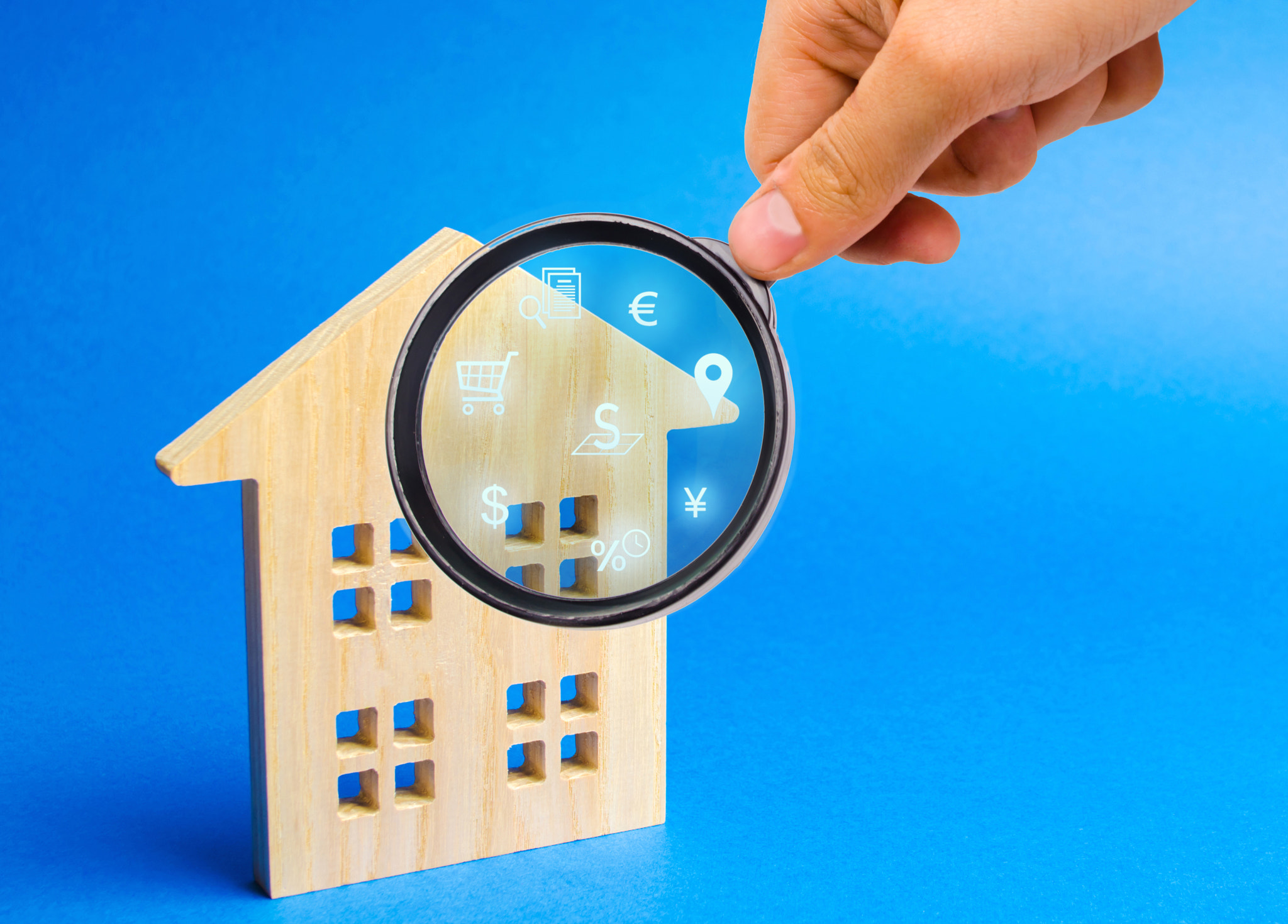 Realtor examines houses through a magnifying glass. Review of the real estate market, search for the