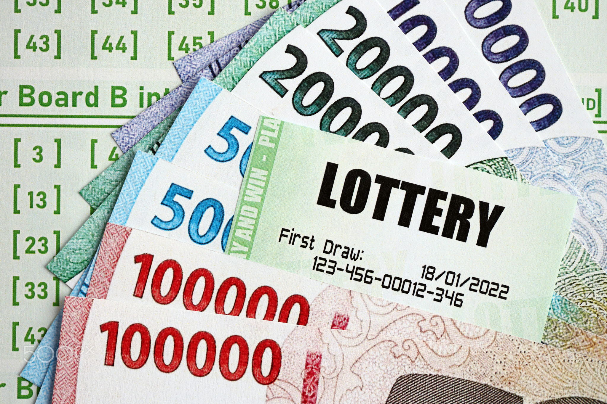 Green lottery tickets and indonesian money bills on blank with numbers for playing lottery
