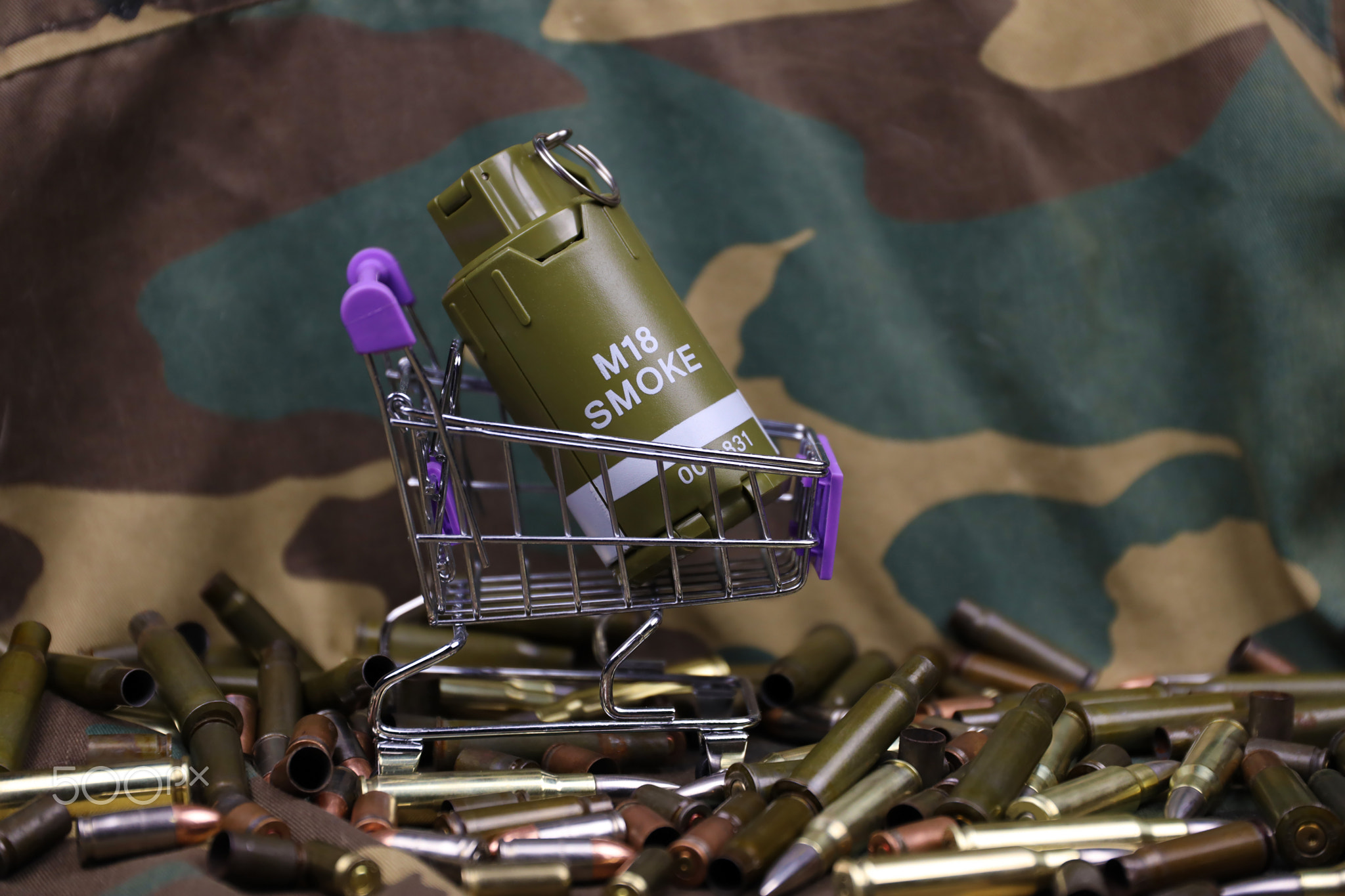 Rifle cartridges in small shopping cart. Big caliber ammo cartridges and hand grenades with a small
